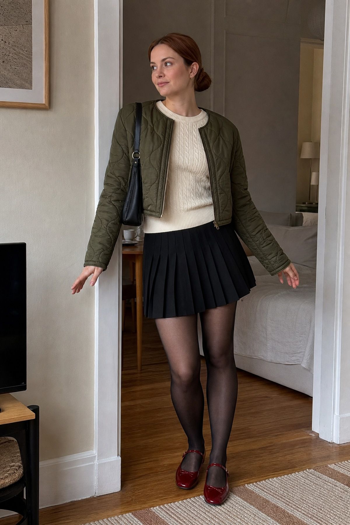 Woman wearing a black pleated mini with a cropped quilted jacket, a black skirt fall outfit