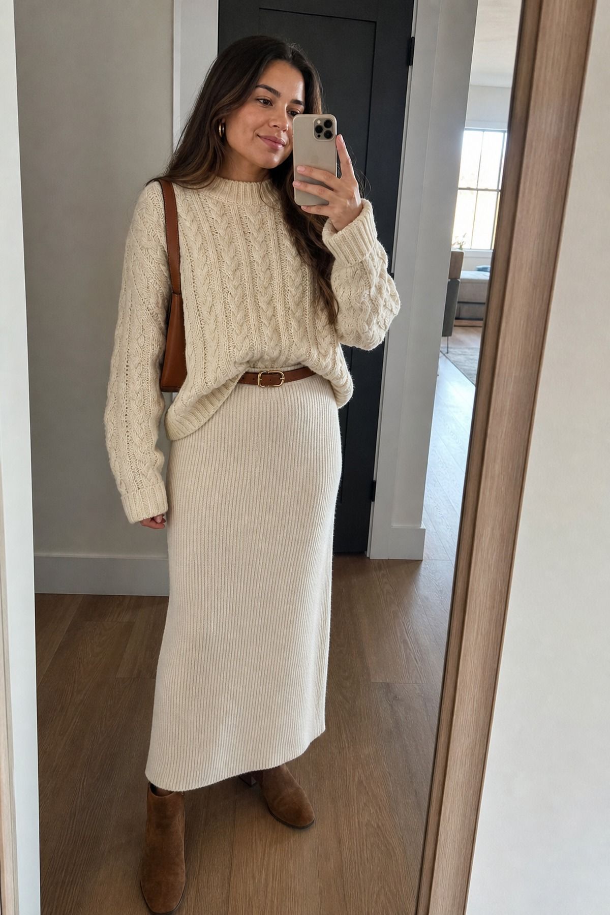 Woman wearing a cream knit maxi skirt with a chunky cable knit, a casual fall maxi skirt outfit