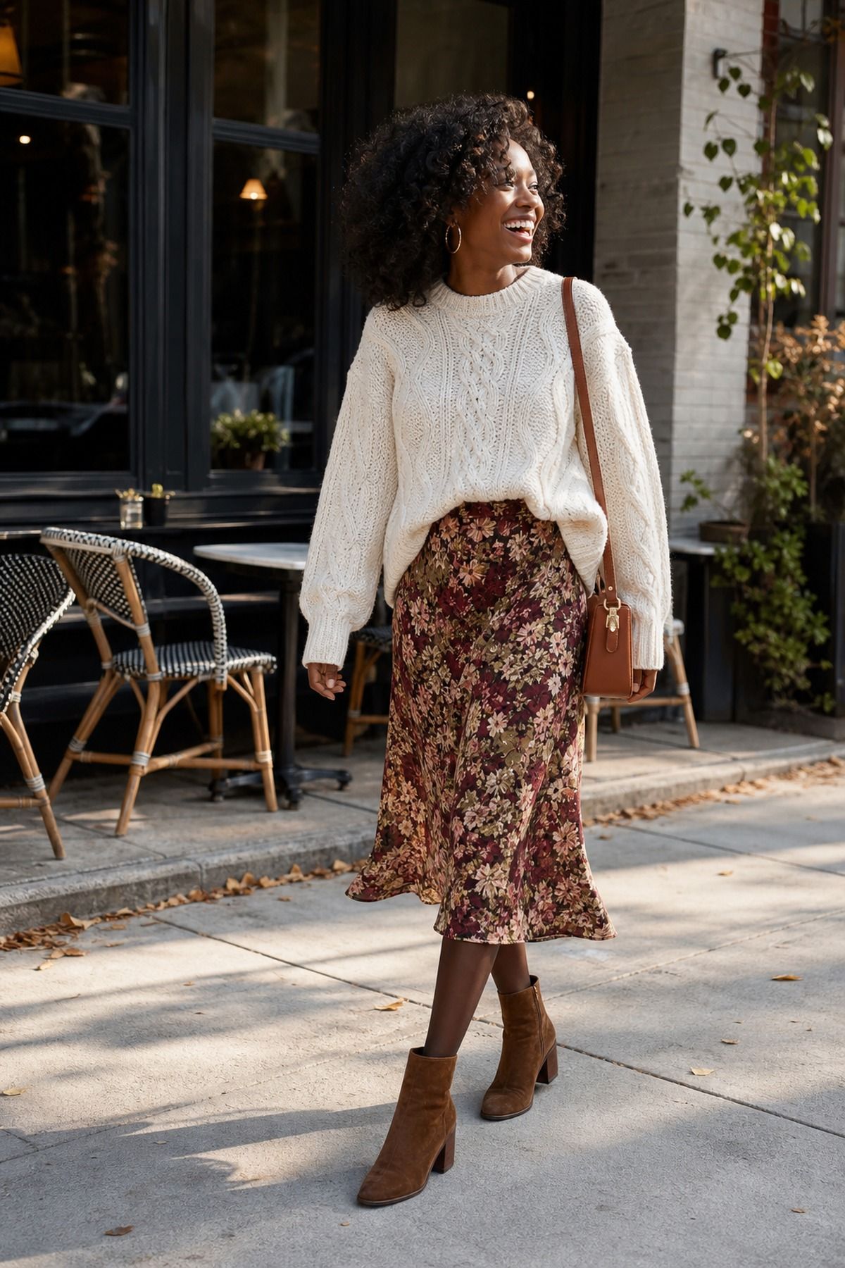 Woman wearing a chunky cream knit with a floral midi skirt, a casual Friendsgiving outfit