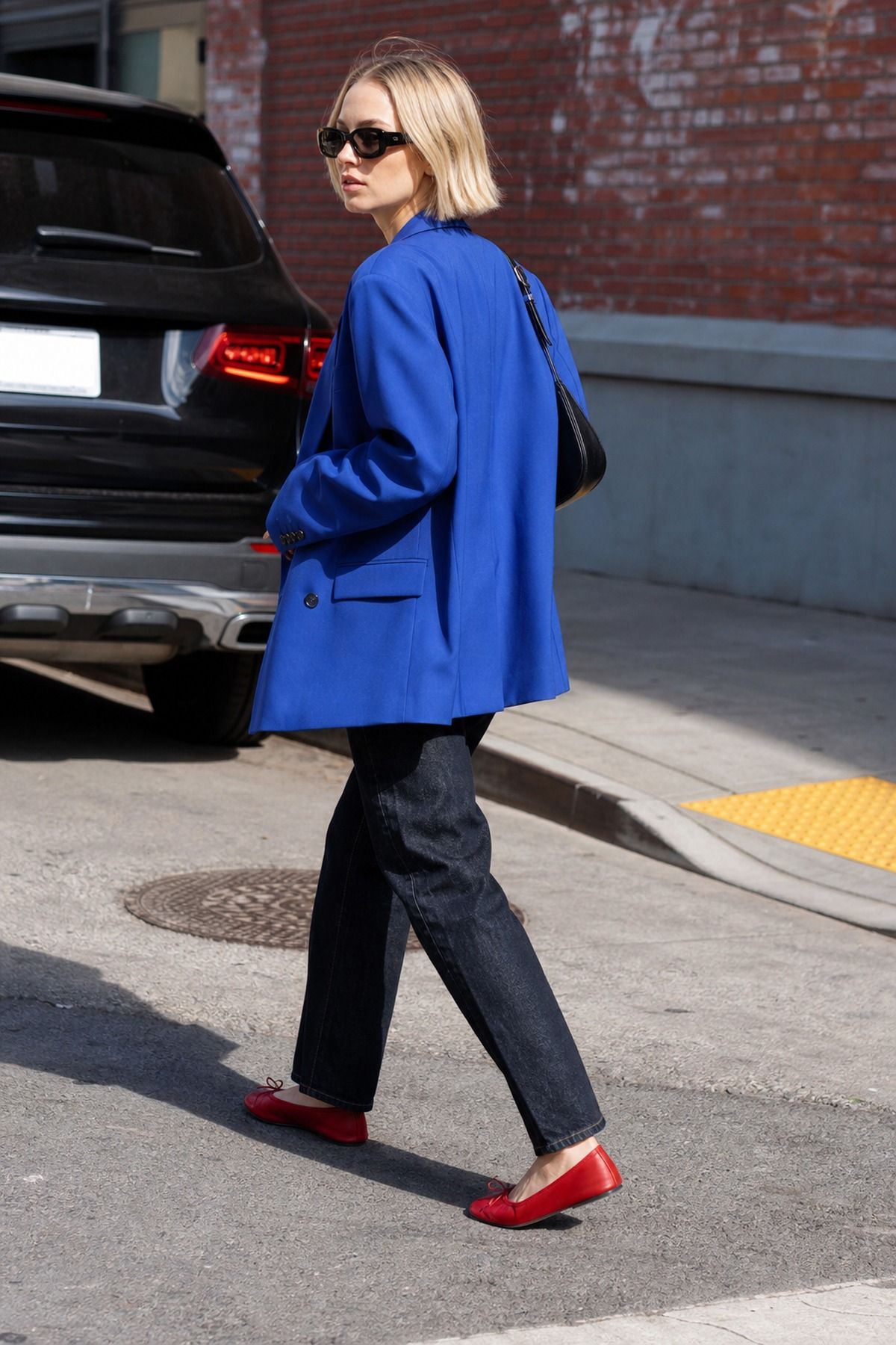 Woman wearing a royal blue blazer with a white tee and dark jean