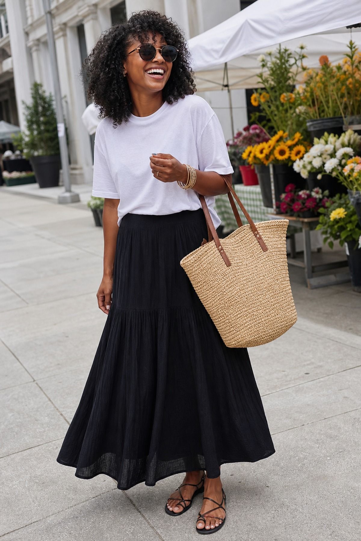 Woman wearing a white tee with a black maxi skirt and raffia tote, a casual t-shirt and skirt outfit