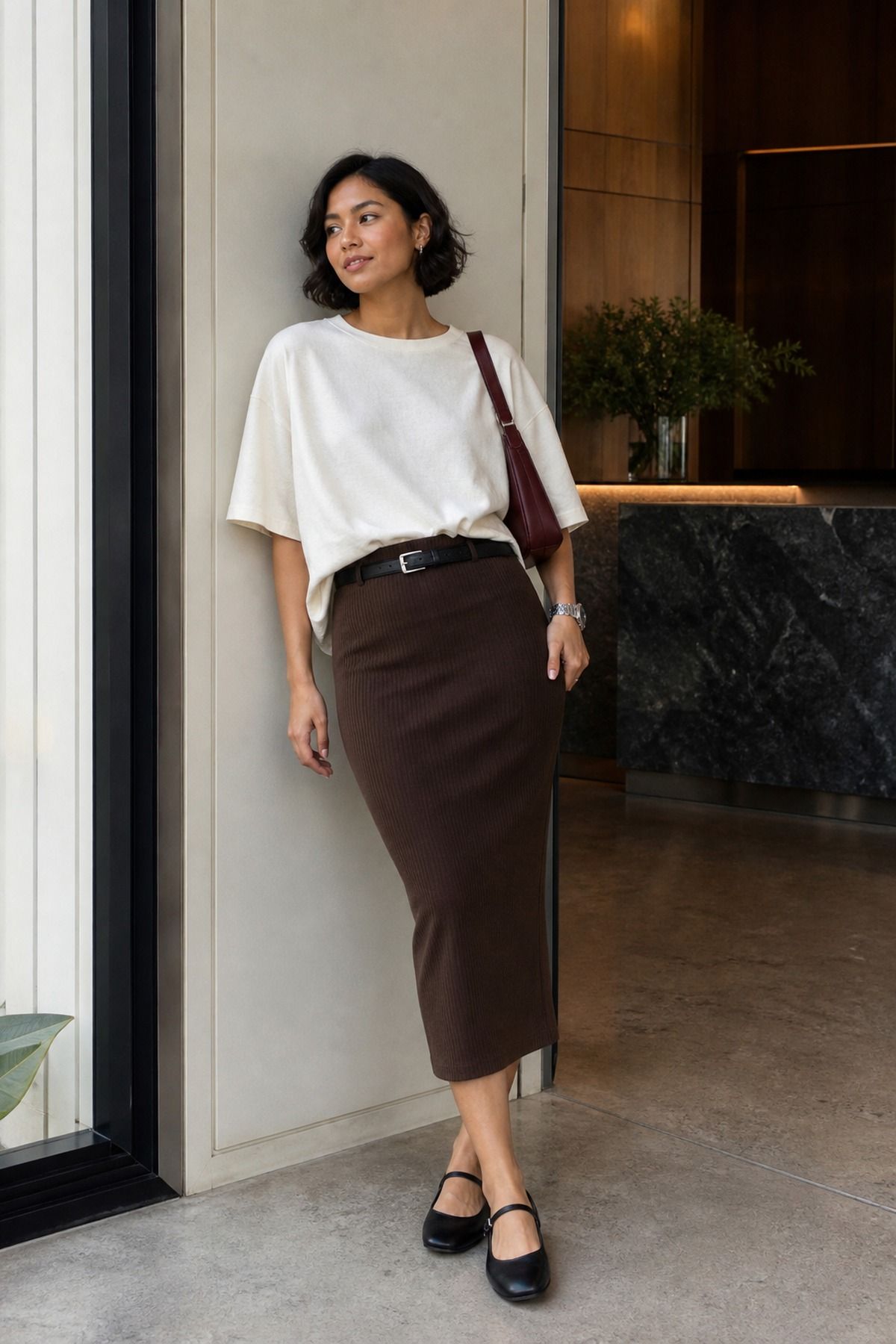 Woman wearing an oversized tee tucked into a fitted pencil skirt, a casual t-shirt and skirt outfit