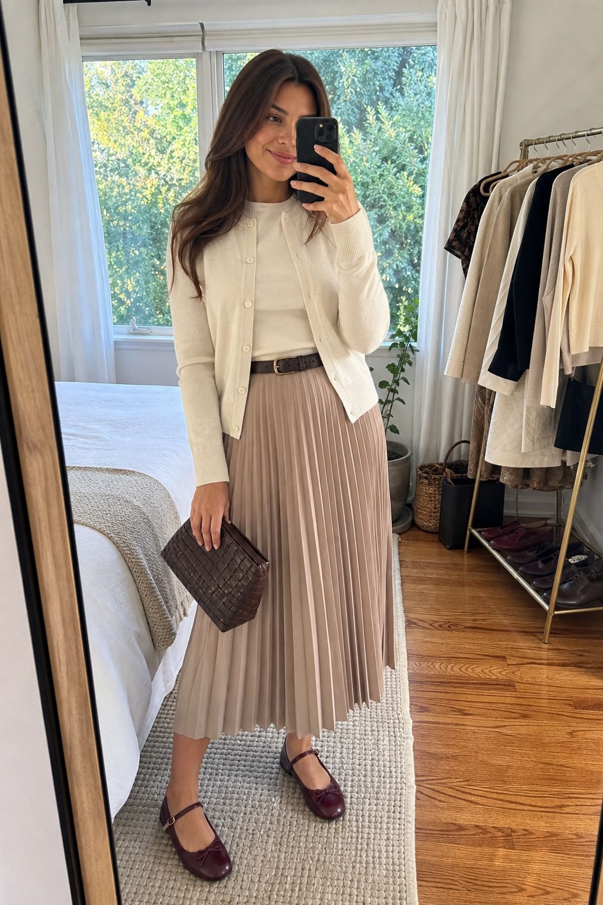 Woman wearing a cream cashmere twin set with a pleated midi skirt, a Thanksgiving outfit
