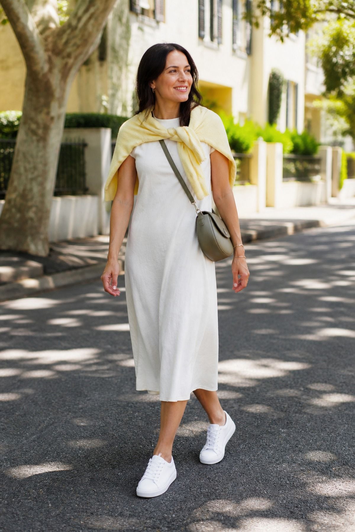 Woman wearing a cardigan with a tank dress and sneakers casual