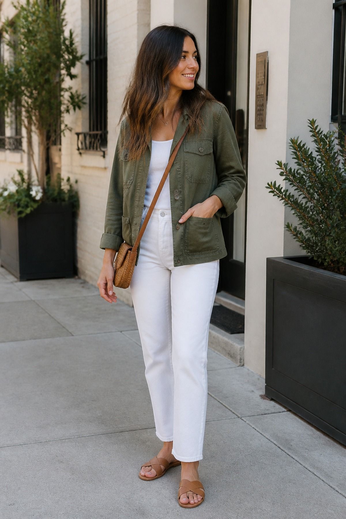 Woman wearing white jeans with a chambray shirt and brown belt casual