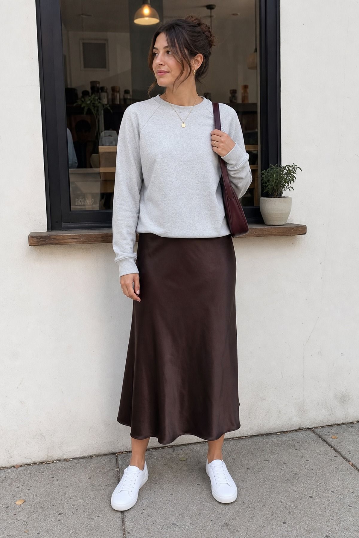 Woman wearing a sweatshirt with a slip skirt, an everyday outfit