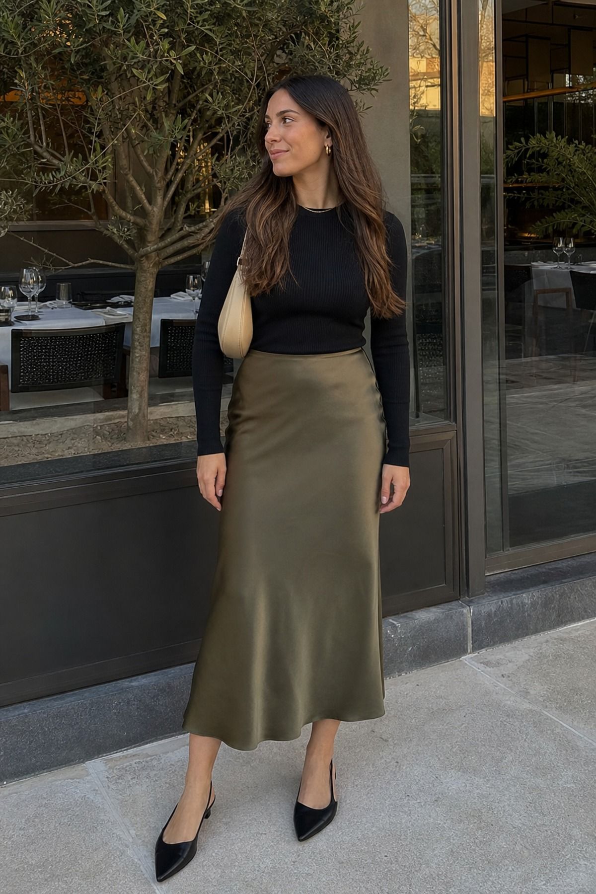 Woman wearing a satin skirt with a fitted long sleeve top, an everyday outfit