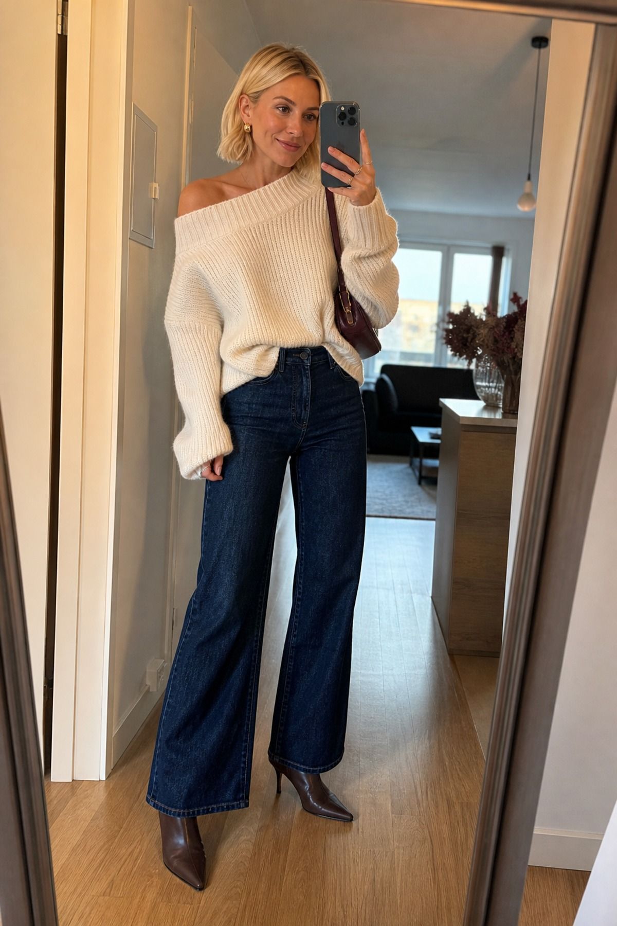 Woman wearing an off-shoulder sweater with wide-leg jeans and heeled boots, a fall brunch outfit