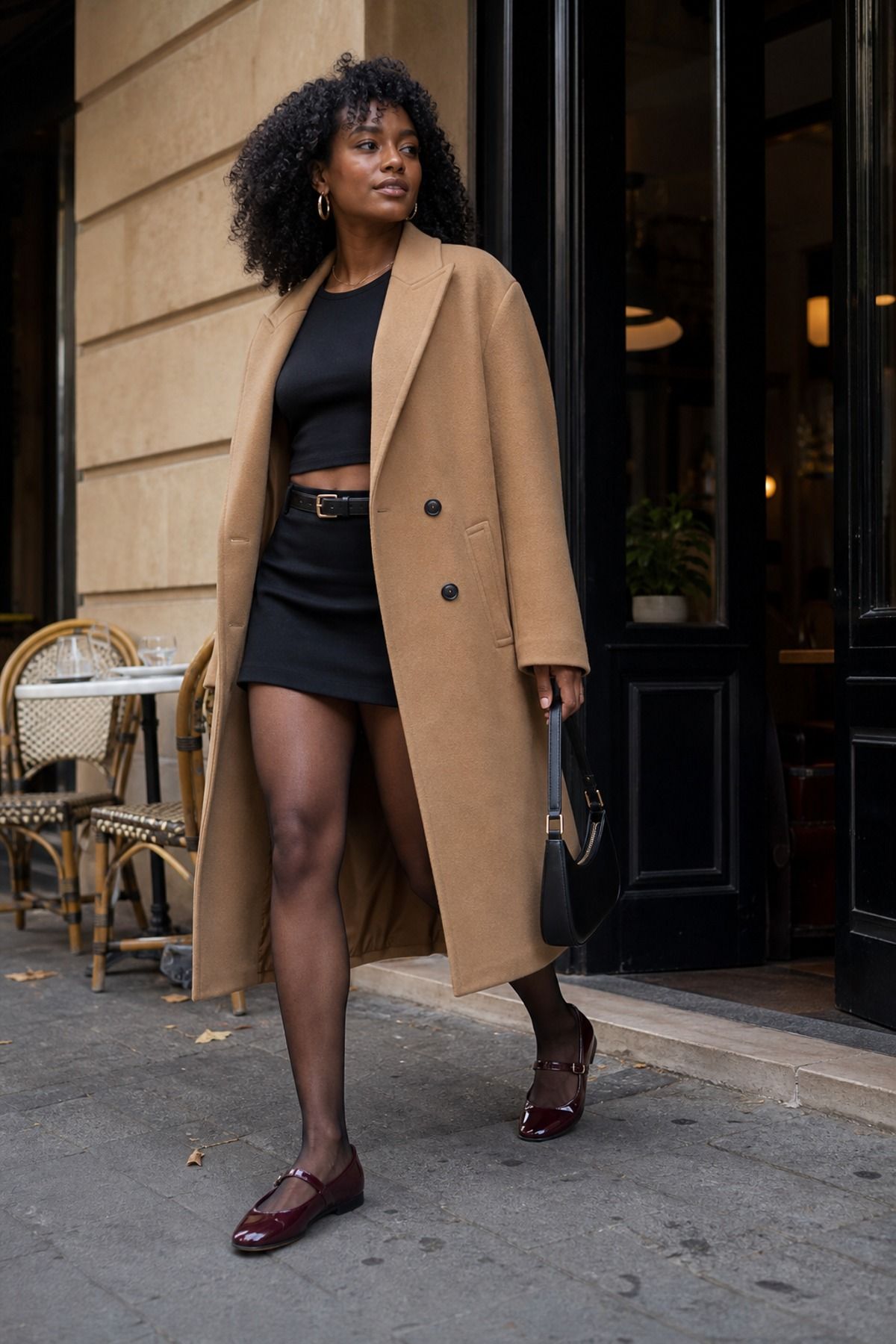 Woman wearing a long blazer over a black crop top and mini skirt, a fall brunch outfit