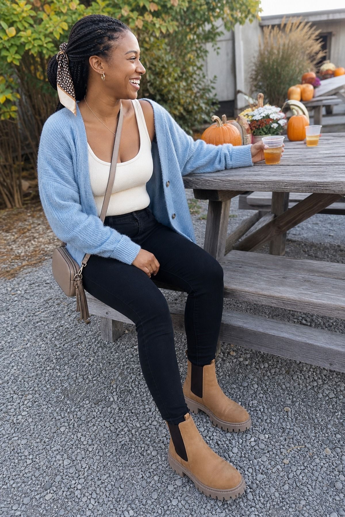 Woman wearing a layered tank and cardigan with skinny jeans, a fall festival outfit