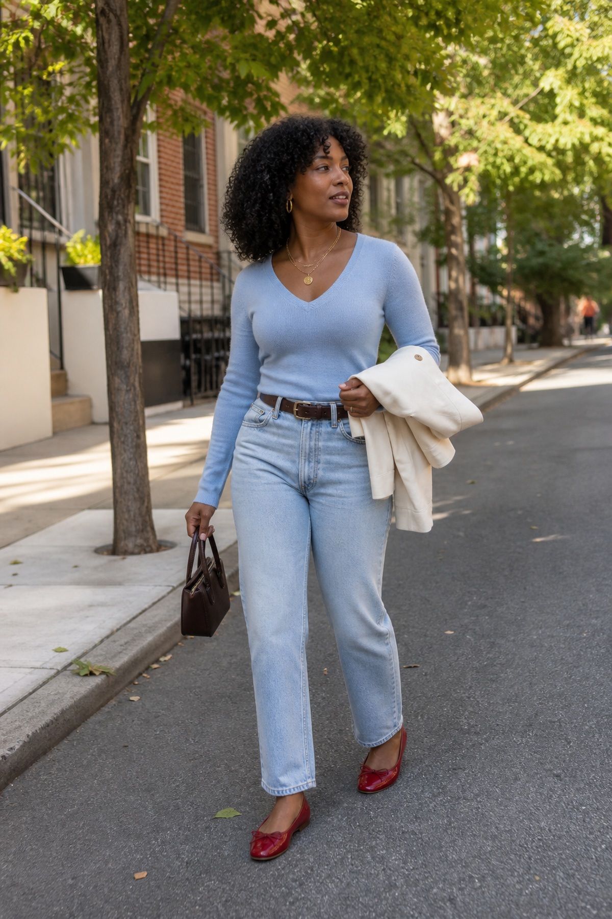 Woman wearing a light-wash stovepipe with a fitted v-neck cashmere, a fall jeans outfit
