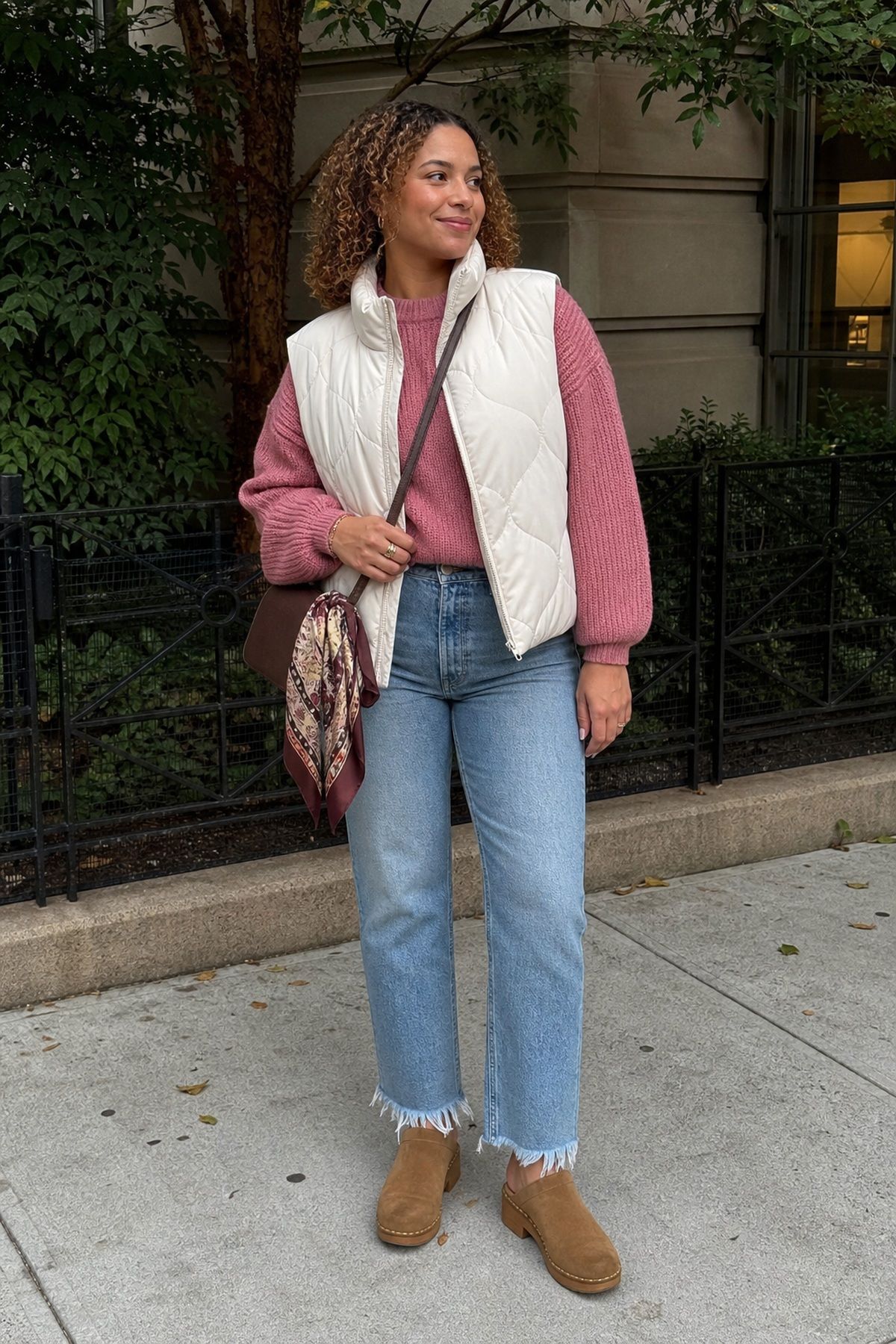 Woman wearing frayed-hem jeans with a chunky knit, a fall jeans outfit