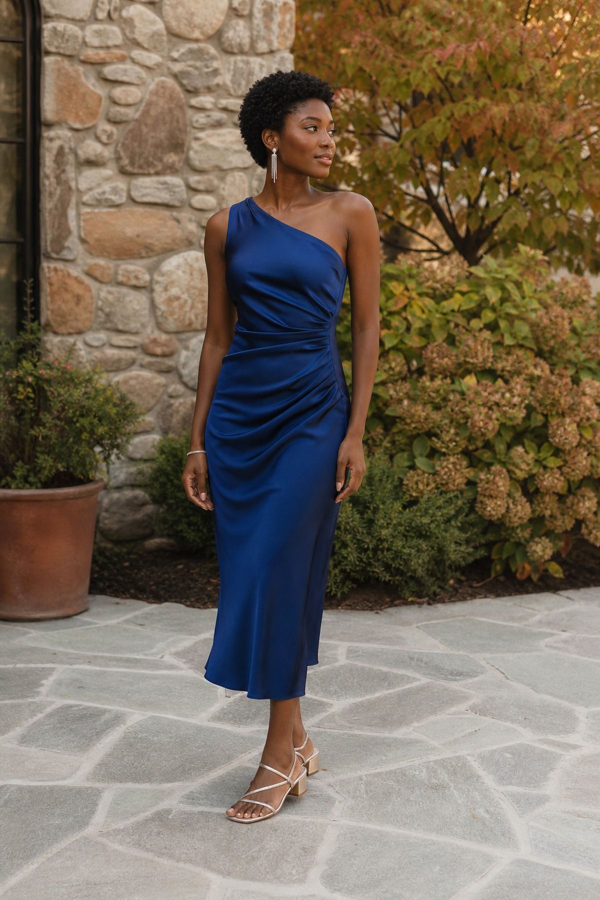 Woman wearing an one-shoulder midi dress in sapphire or plum, a fall wedding guest outfit