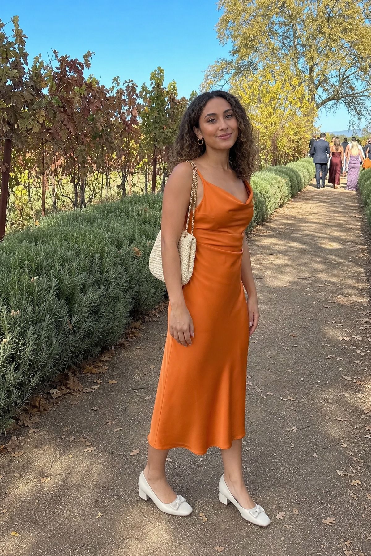 Woman wearing sunset orange midi dress for daytime ceremonies, a fall wedding guest outfit