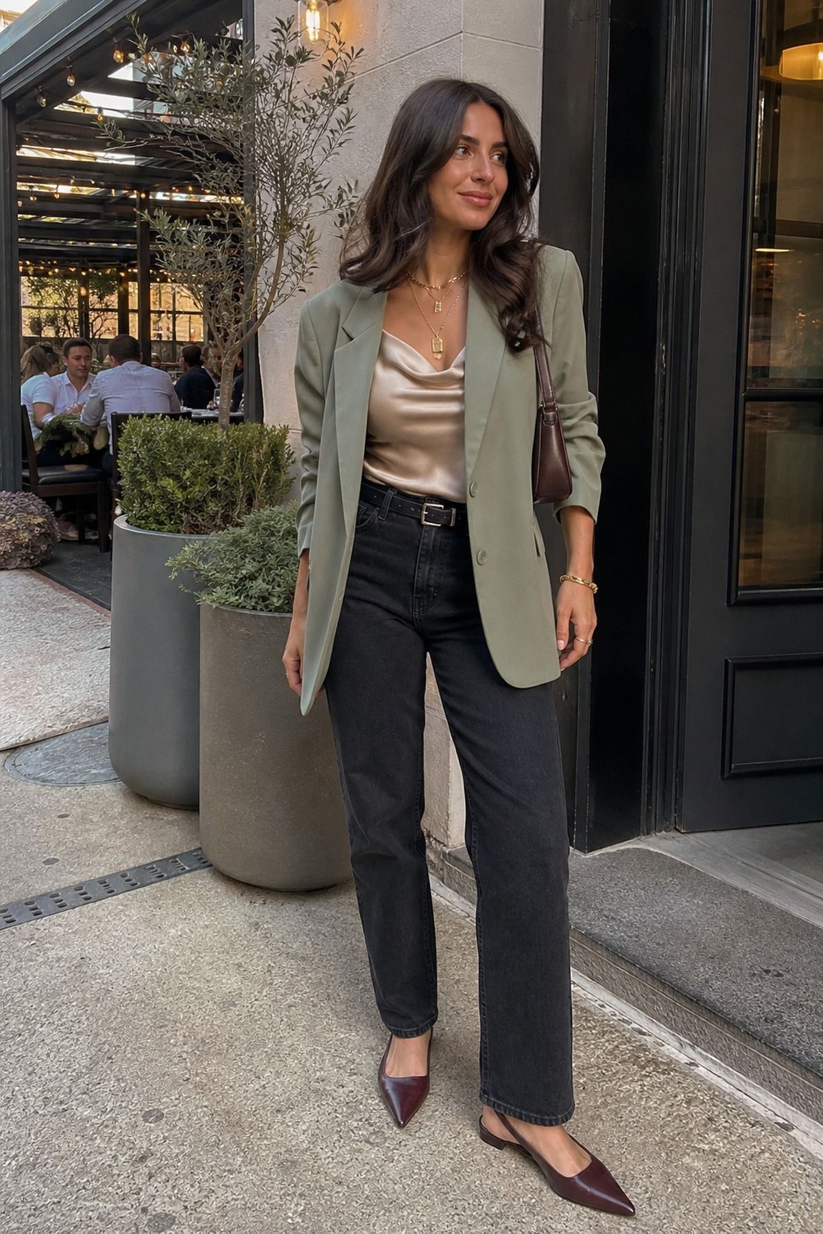 Woman wearing dark jeans with a satin cami and blazer, a spring dinner outfit