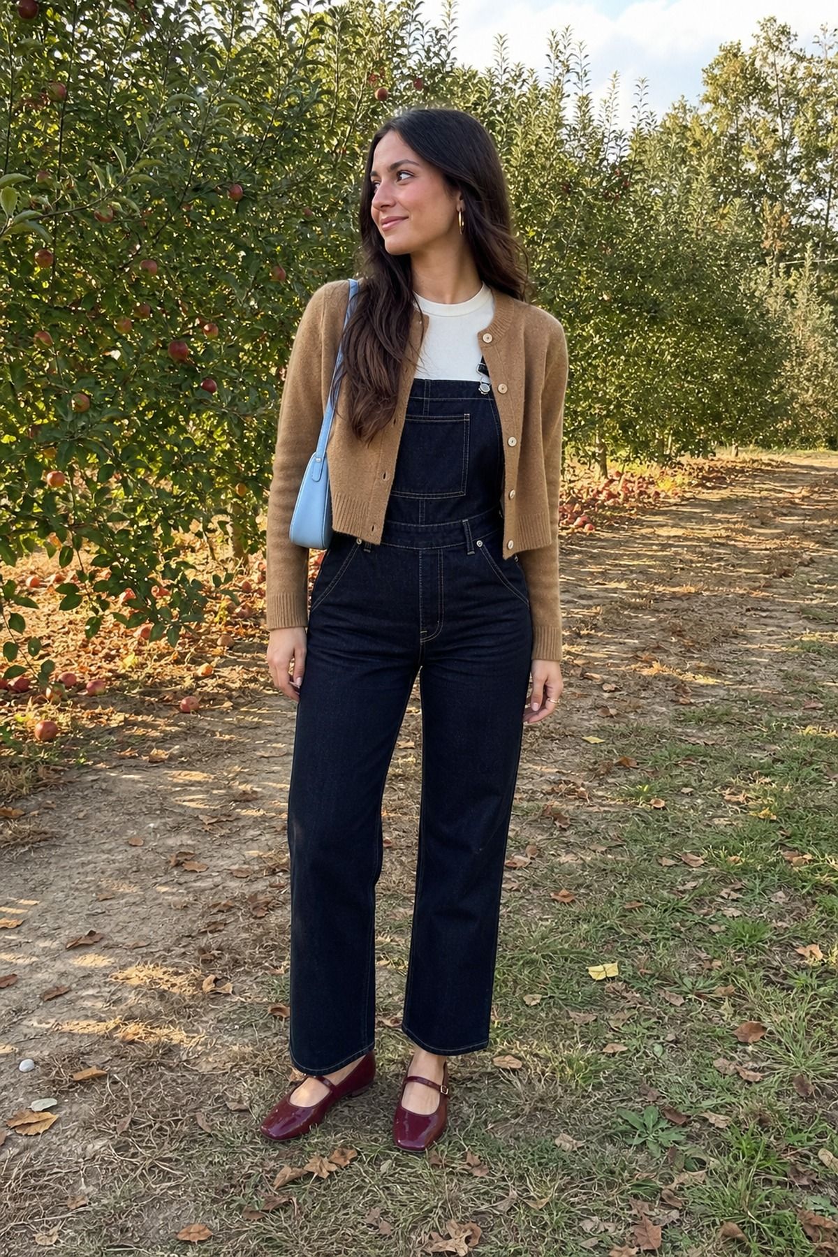 Woman wearing a cardigan with overalls, a fall apple picking outfit