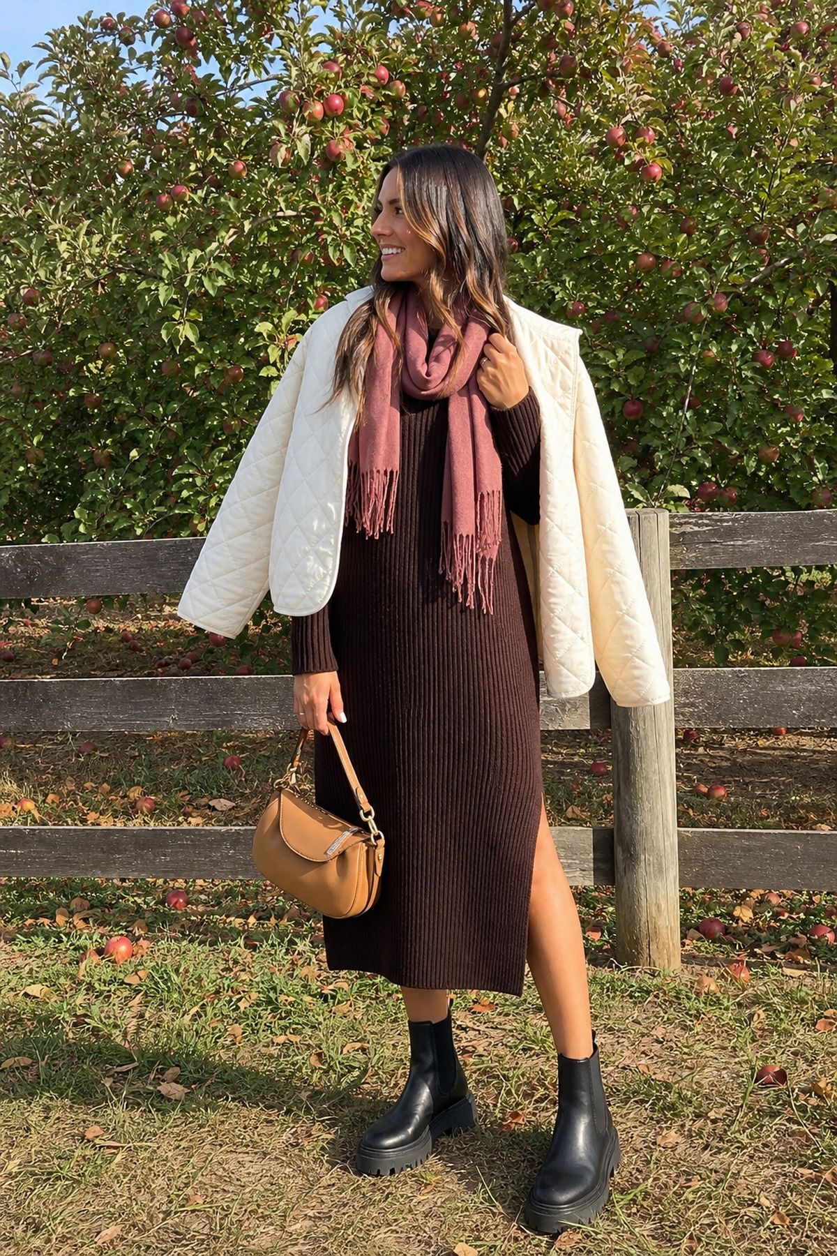 Woman wearing a sweater dress with lug boots, a fall apple picking outfit