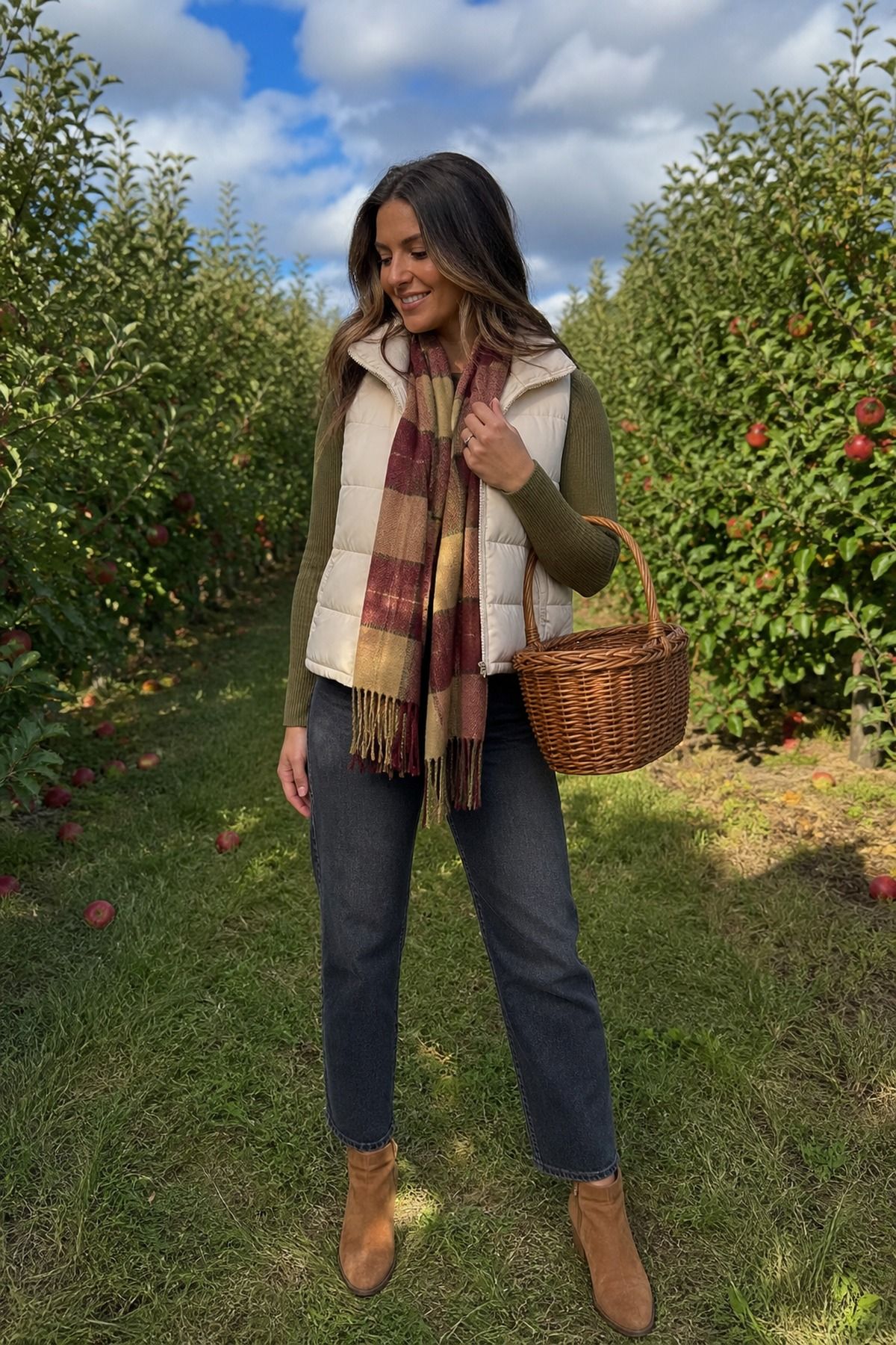 Woman wearing a puffer vest with a plaid scarf, a fall apple picking outfit