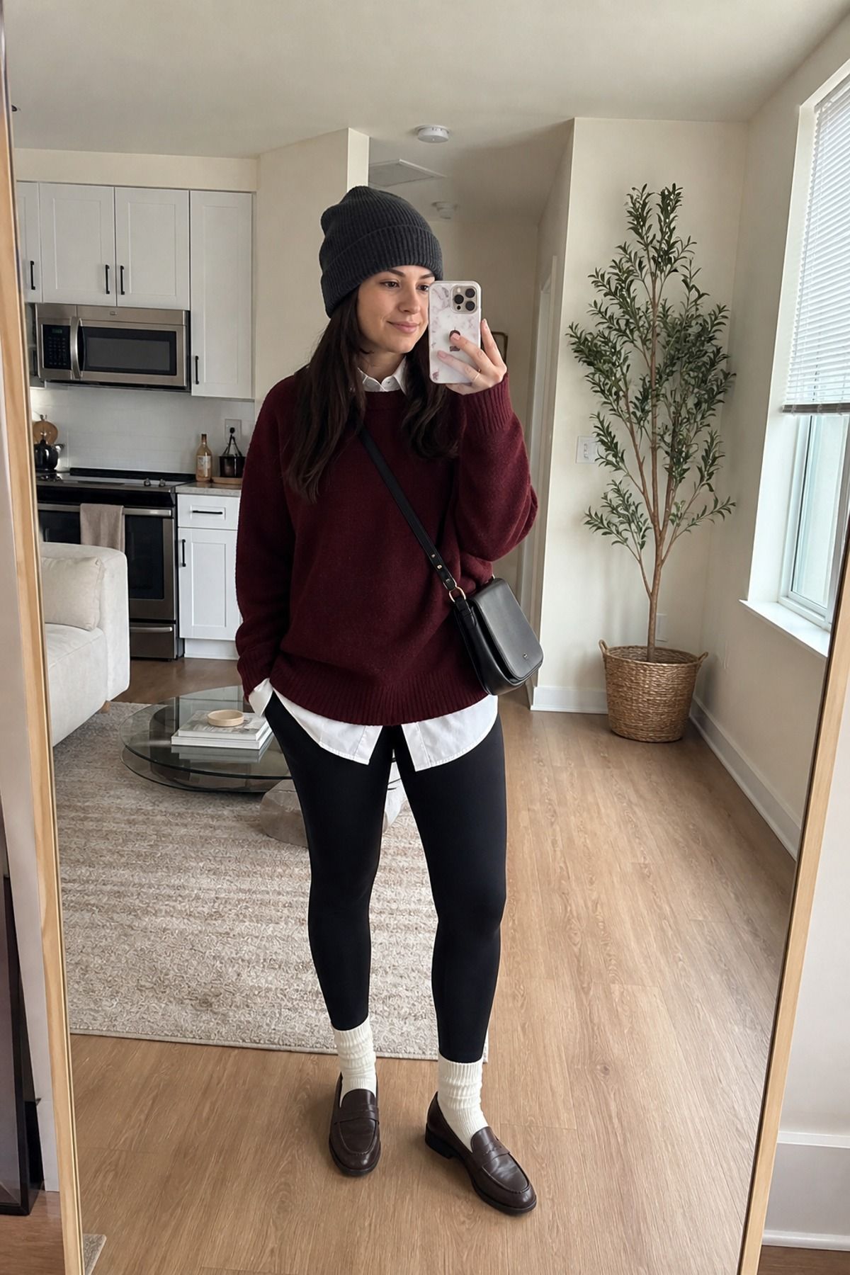 Woman wearing an oversized button down with a sweater, a winter leggings outfit