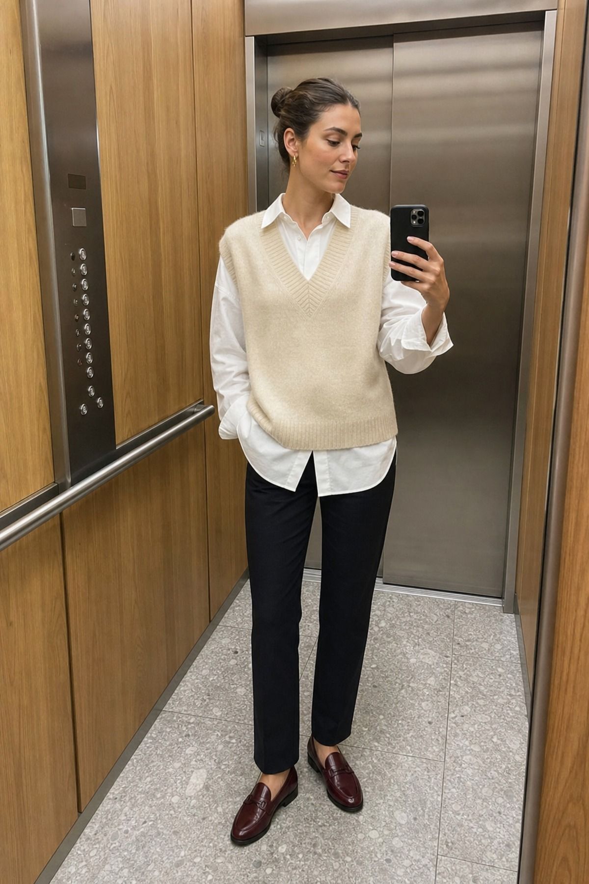 Woman wearing a sweater vest with a poplin shirt, a 60 degree weather outfit