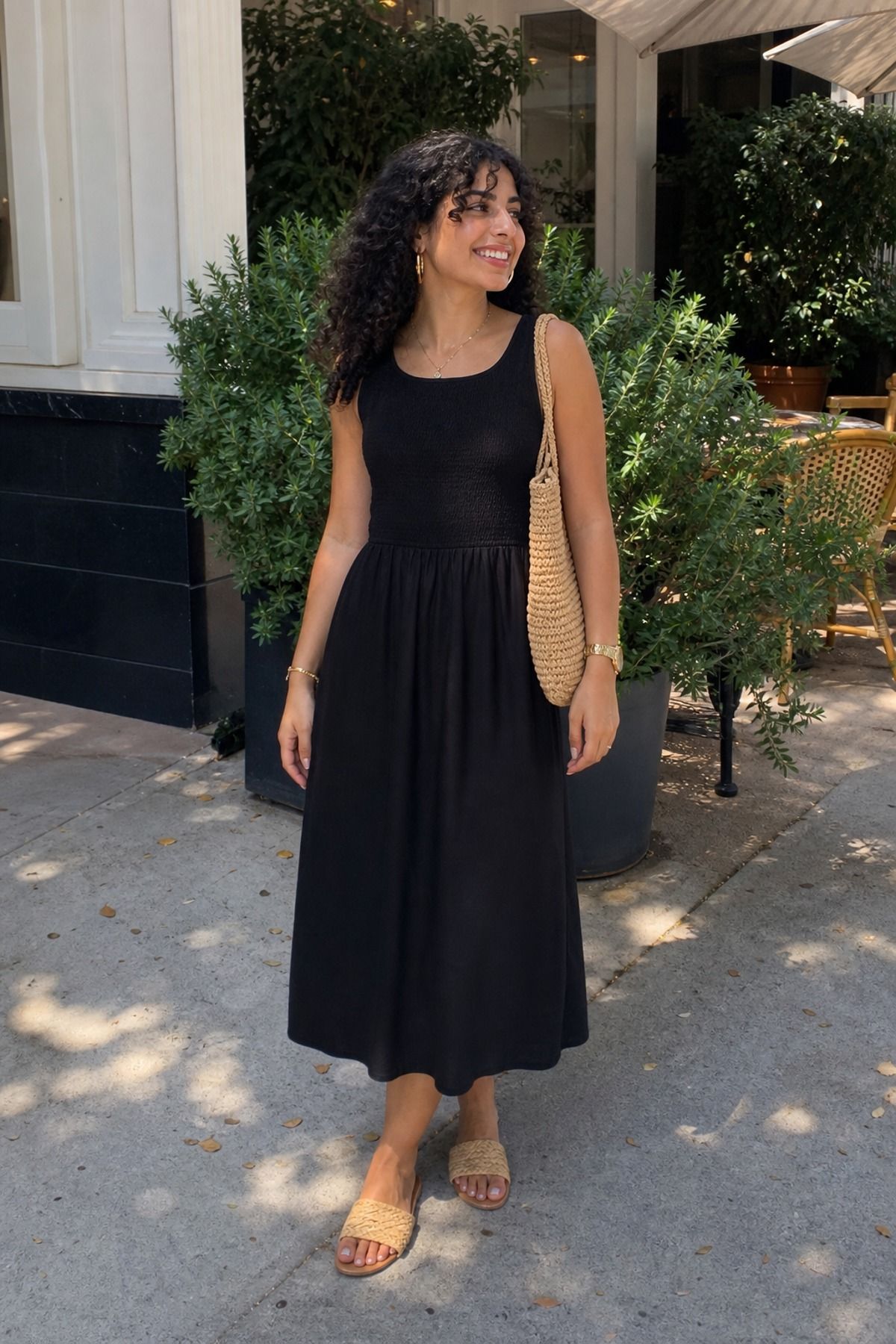 Woman wearing a black dress with raffia accessories, a brunch outfit