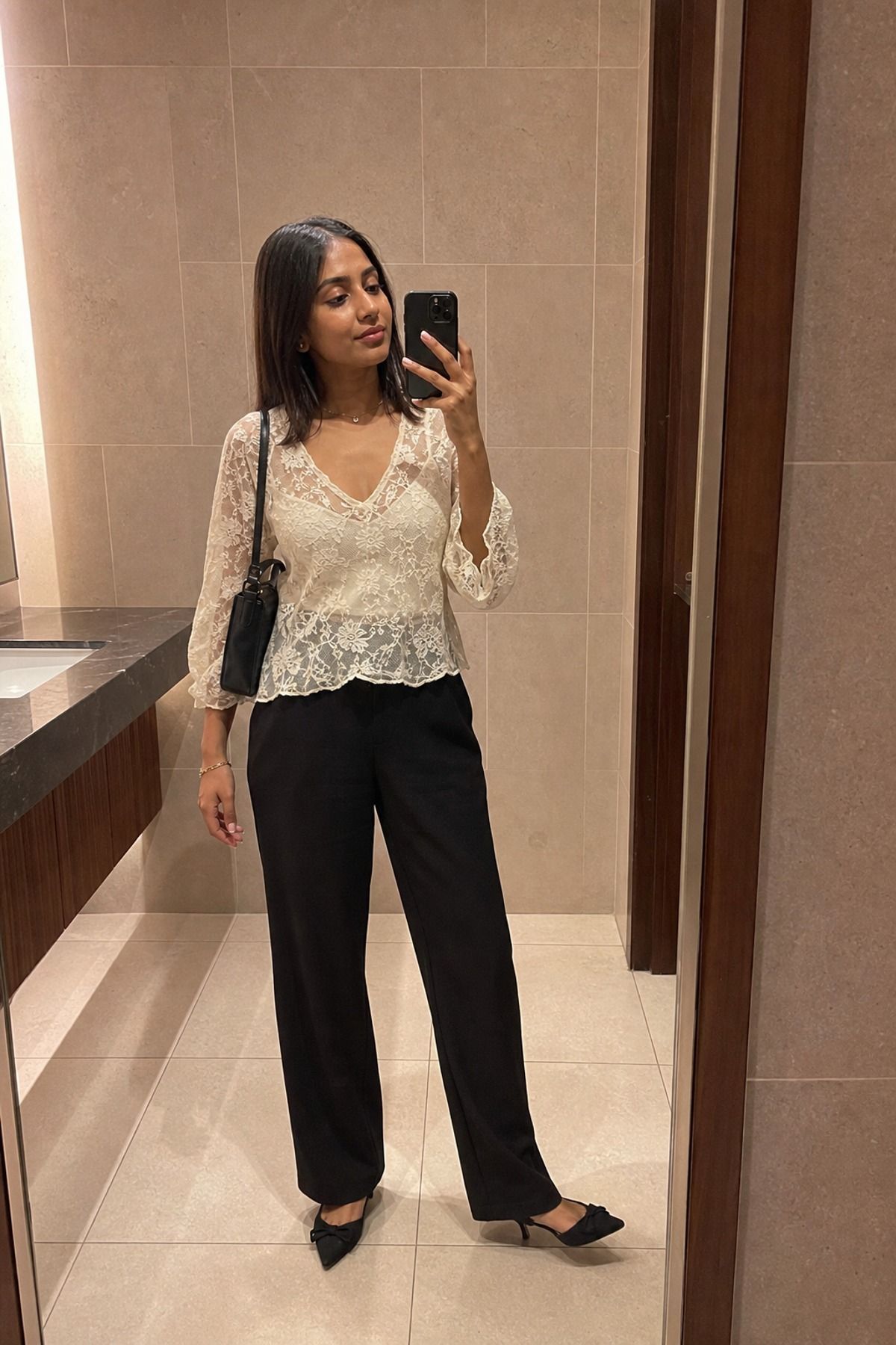 Woman wearing black trousers with a lace top casual dinner