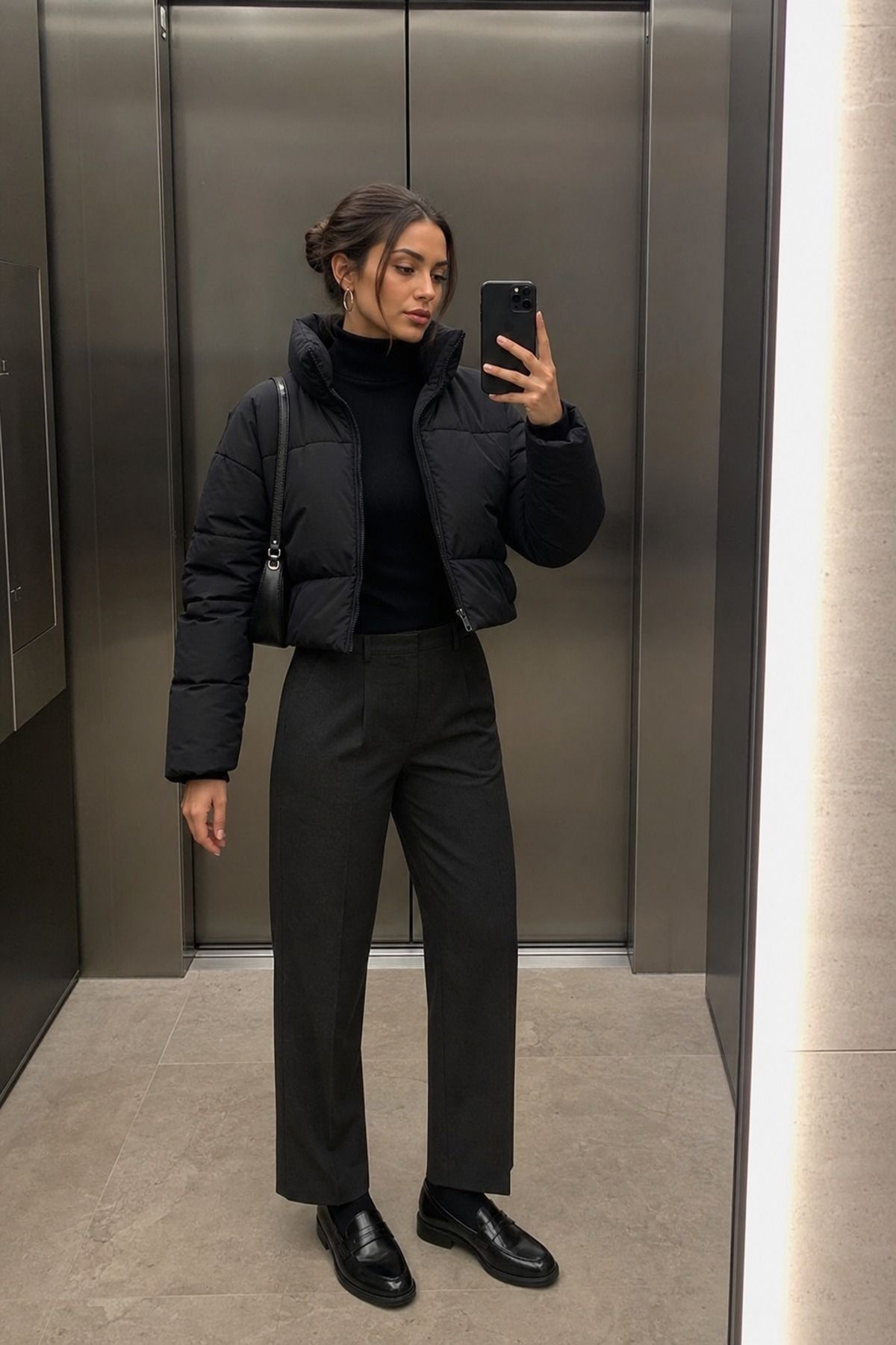 Woman wearing a black puffer with monochrome layers, a puffer jacket outfit