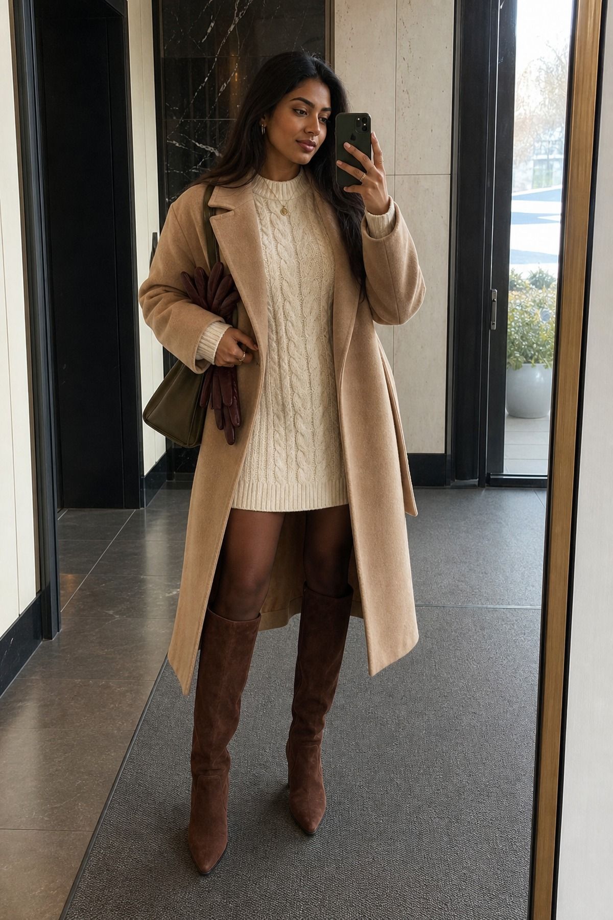 Woman wearing a cream sweater dress with brown boots, a winter dress outfit