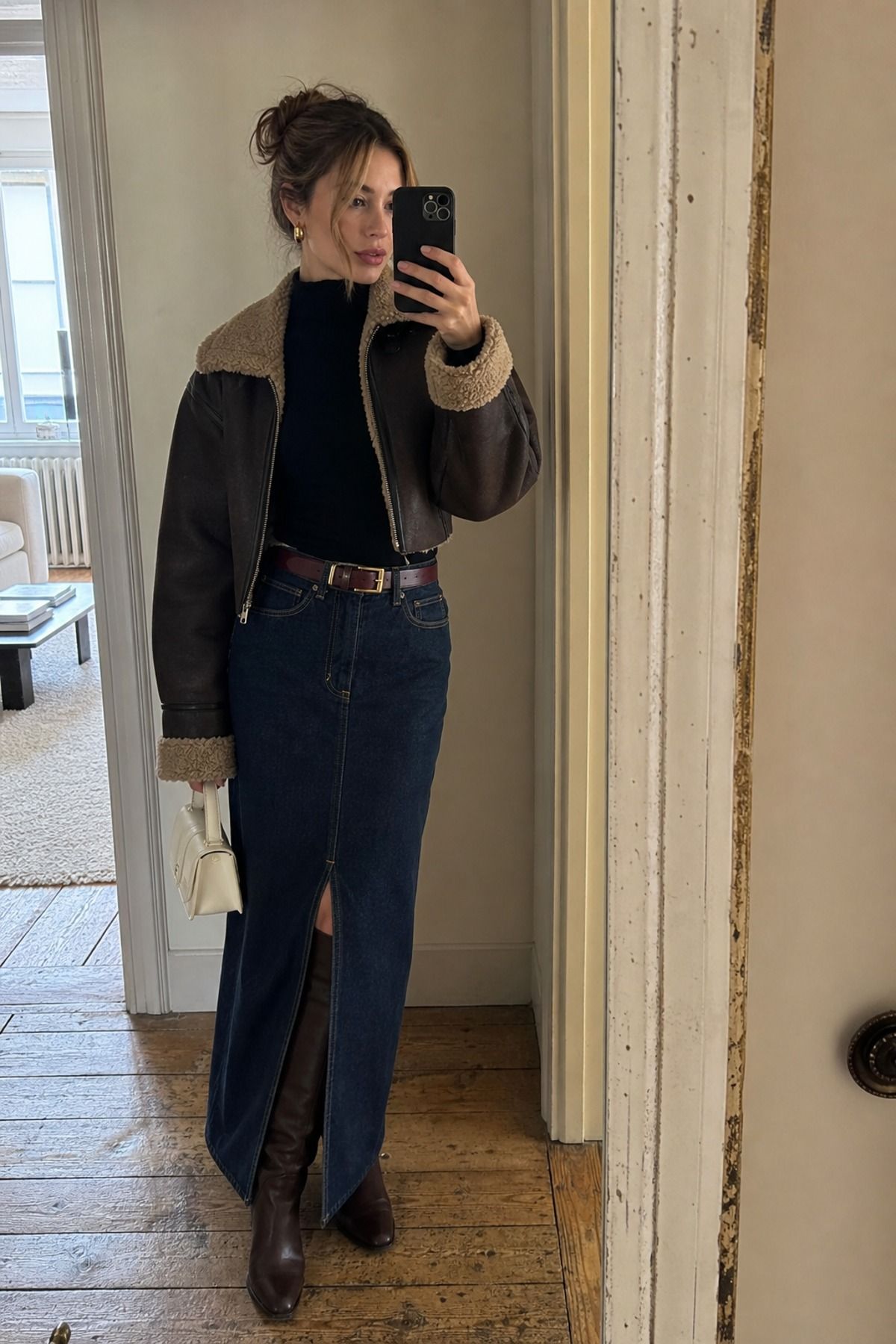 Woman wearing a denim maxi skirt with tall boots, a winter skirt outfit