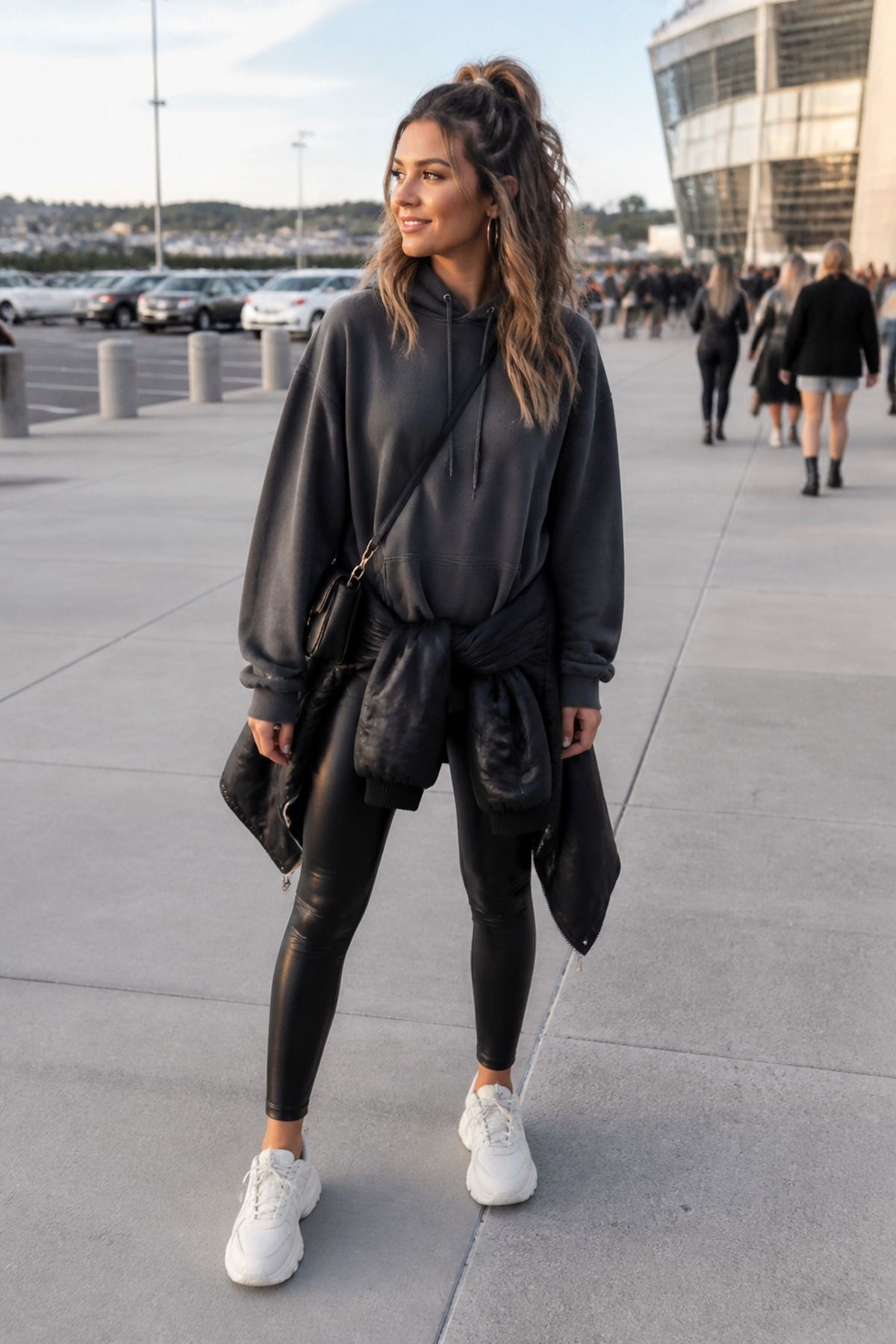 Woman wearing a hoodie with faux leather leggings, a casual concert outfit