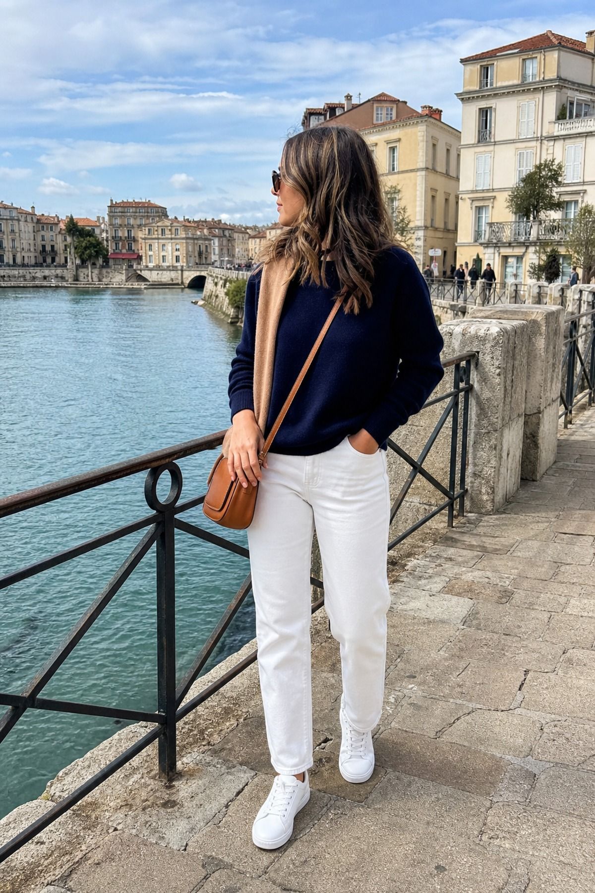 Woman wearing white jeans with a navy sweater, an Europe travel outfit