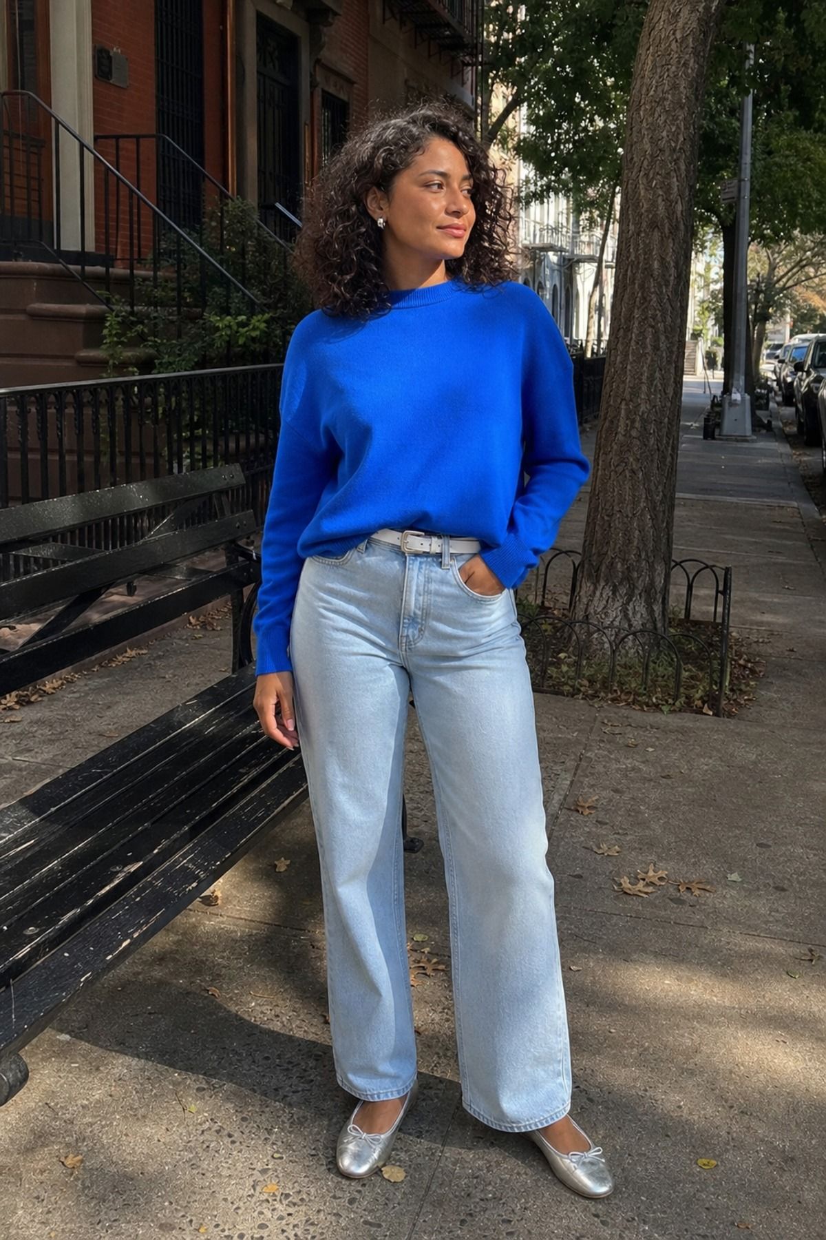 Woman wearing light wash jeans with a bright sweater