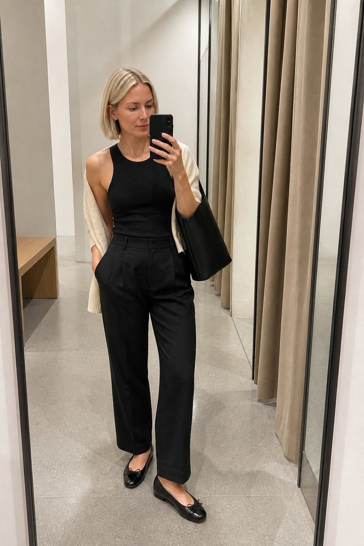 Woman wearing black trousers with a ribbed tank, a shopping day outfit