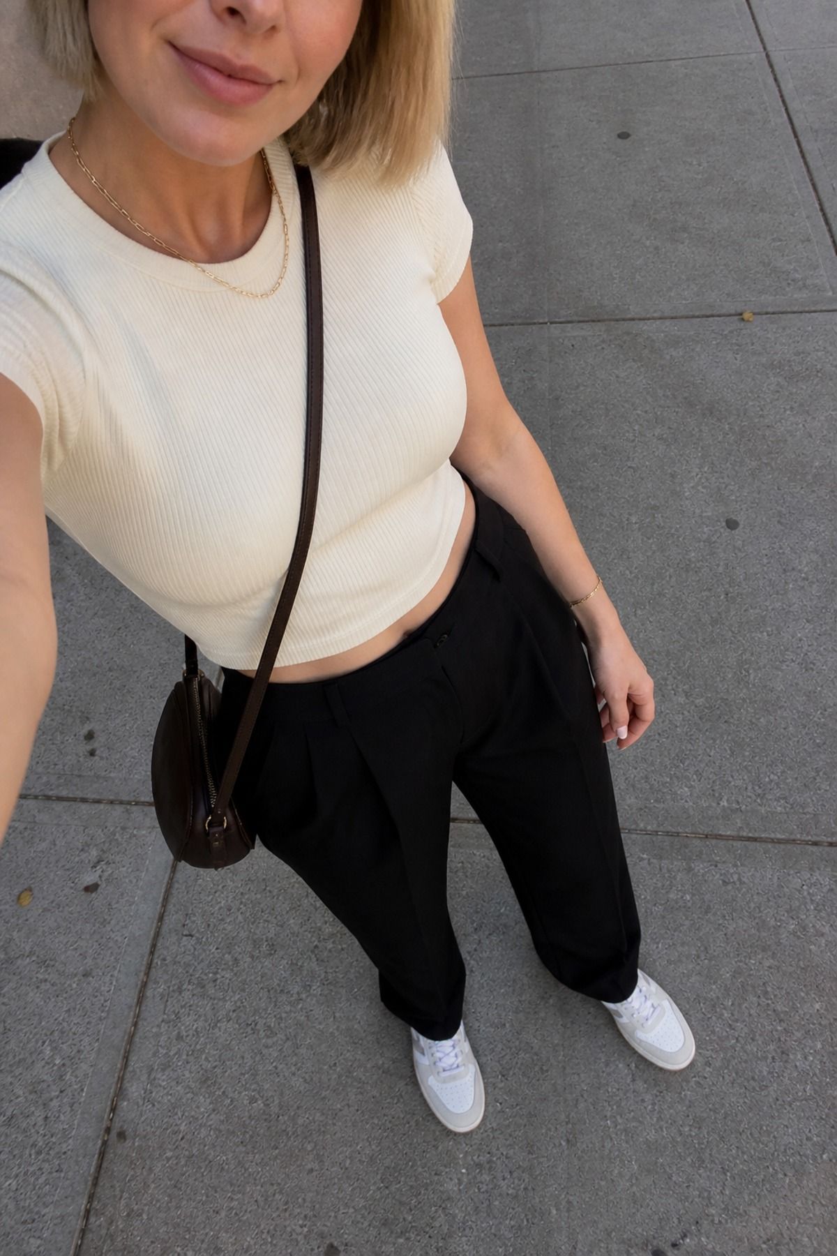 Woman wearing black trousers with sneakers