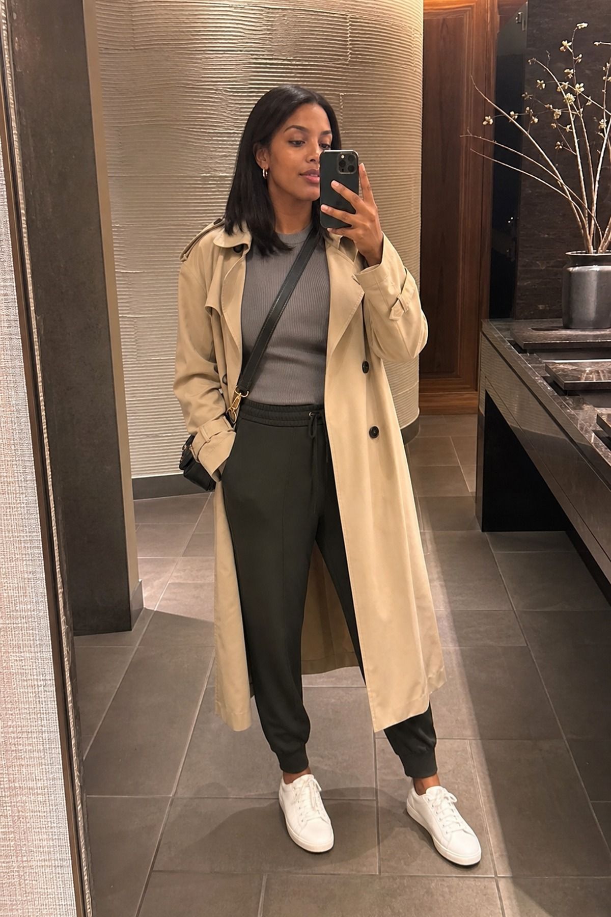 Woman wearing joggers with a trench coat