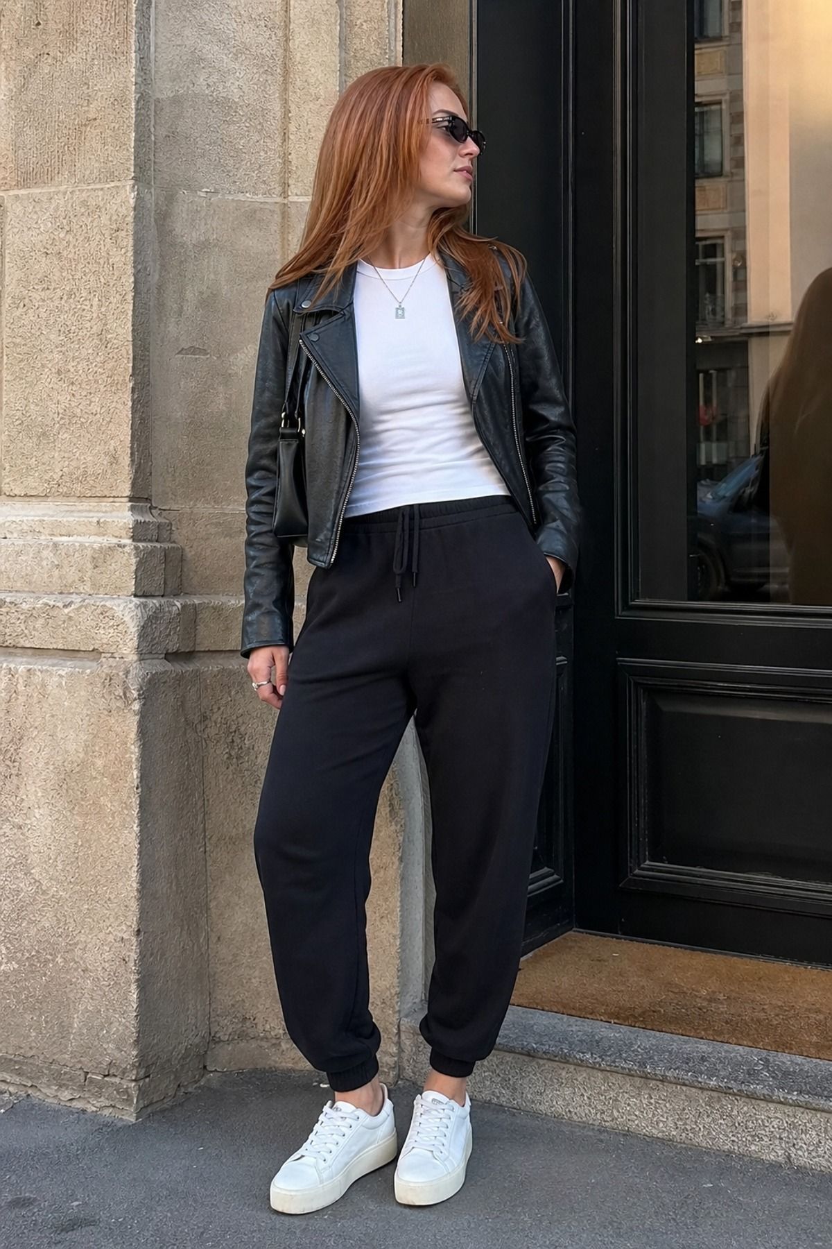 Woman wearing joggers with a leather jacket