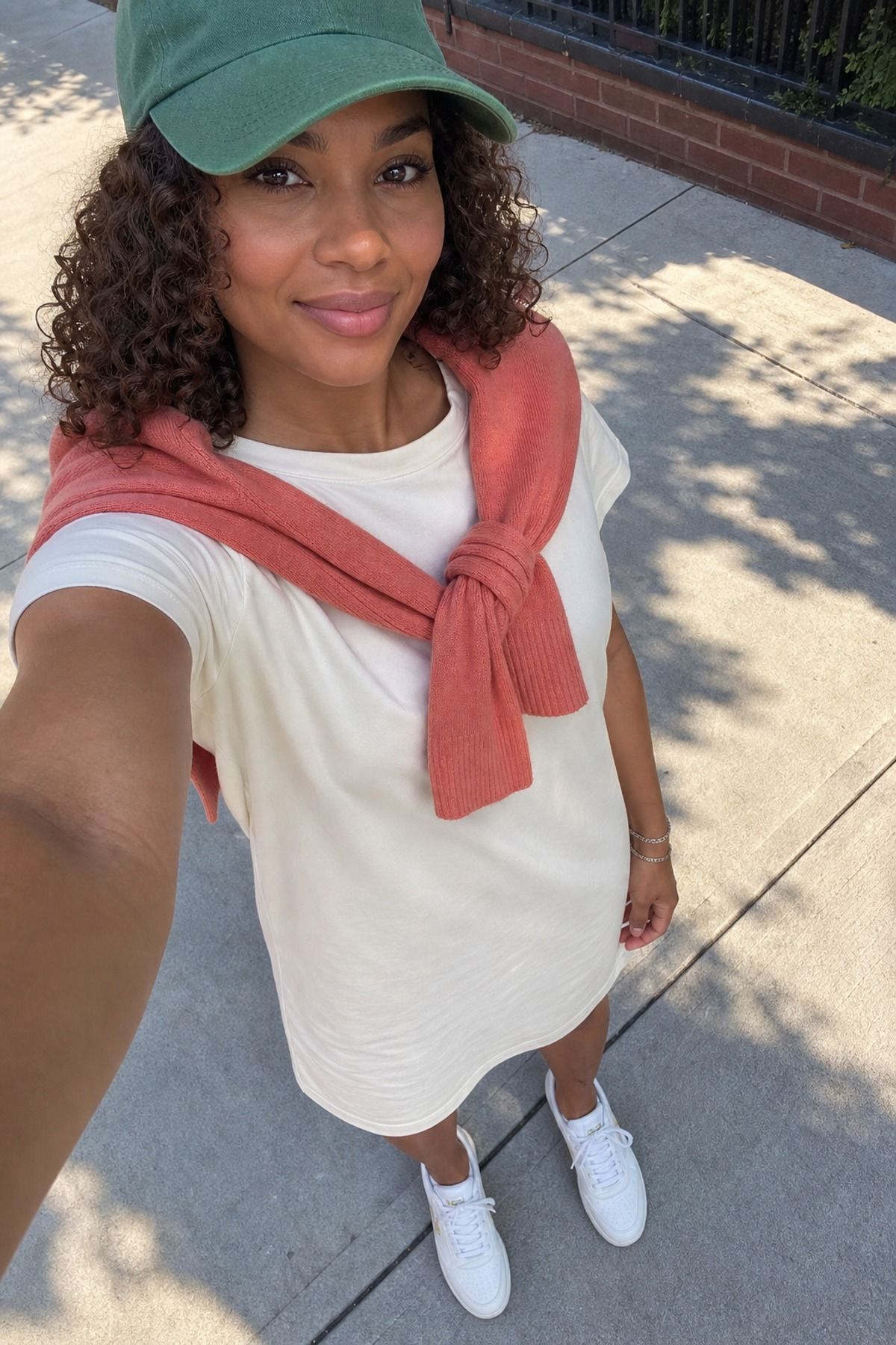 Woman wearing a t-shirt dress with a sweater over it