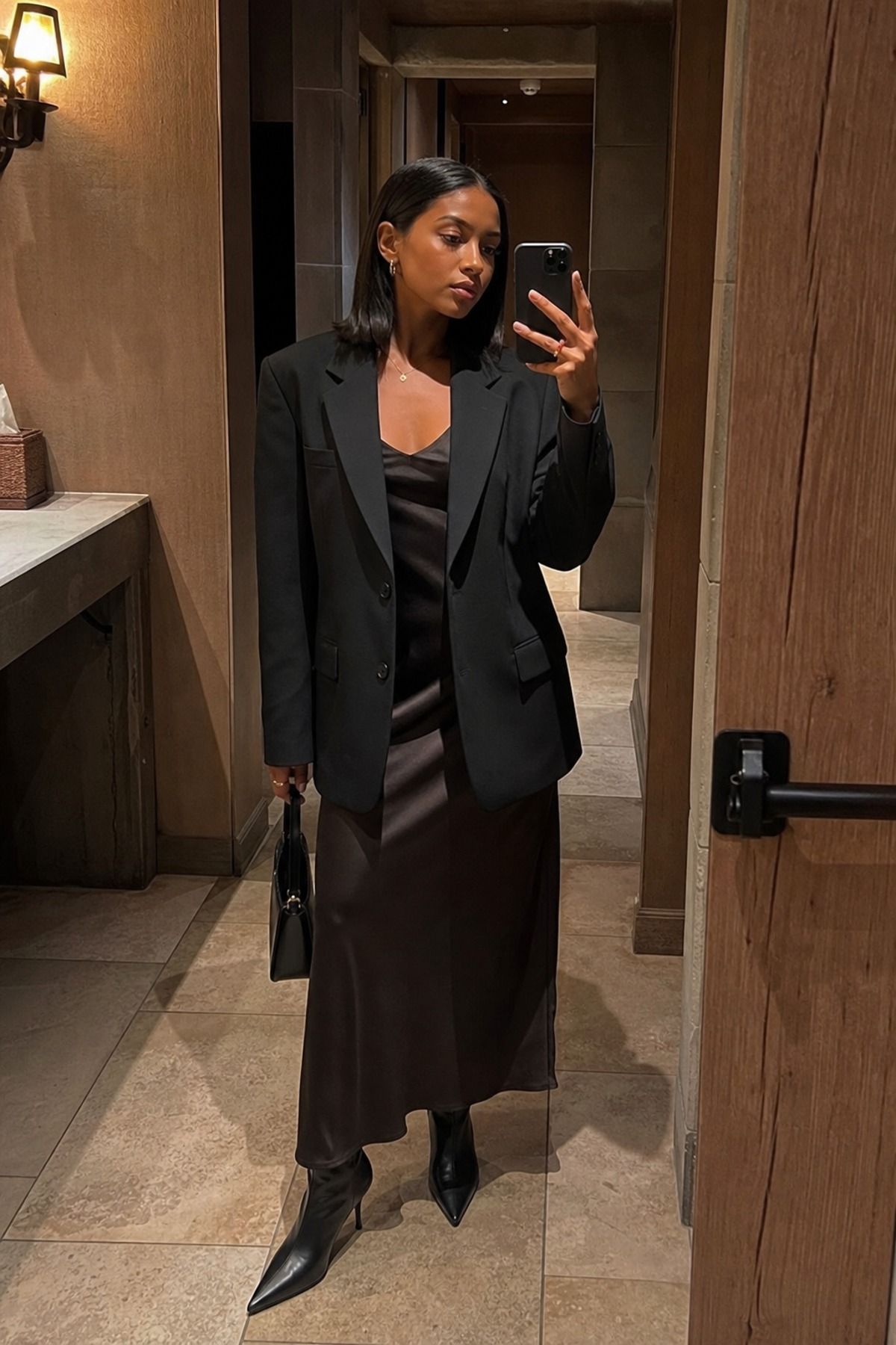 Woman wearing a black blazer with a slip skirt