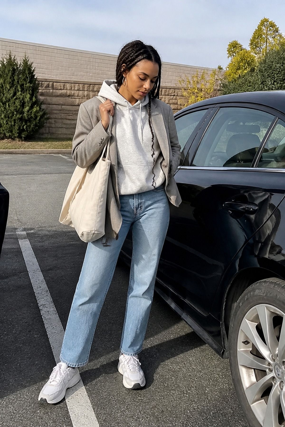 Woman wearing a blazer over a hoodie and jeans