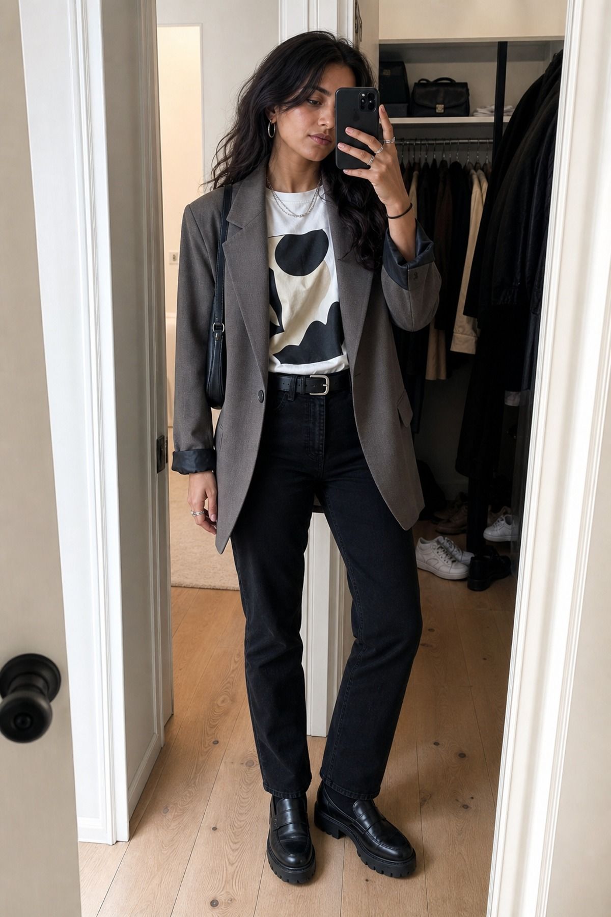 Woman wearing a blazer with a graphic tee and black jeans