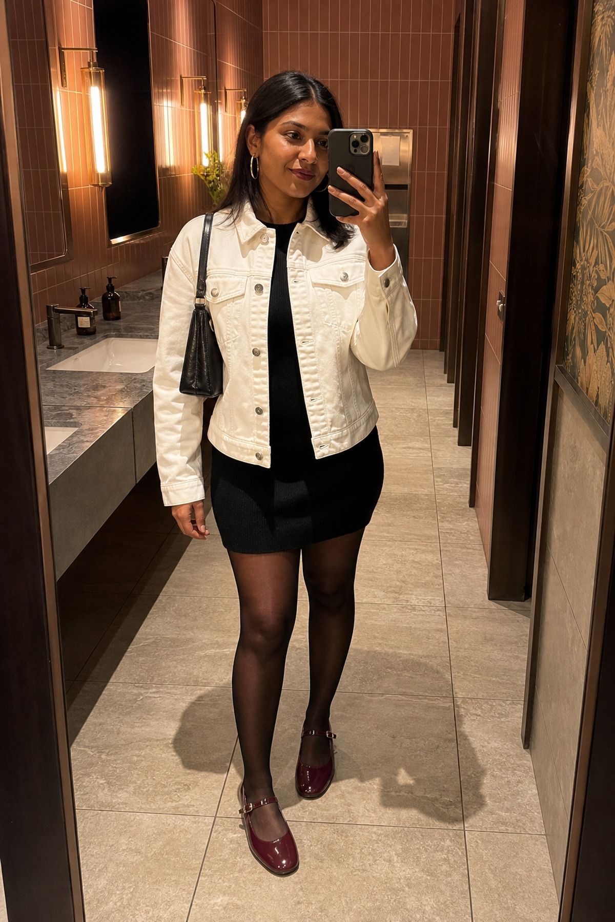 Woman wearing a white denim jacket with a black dress