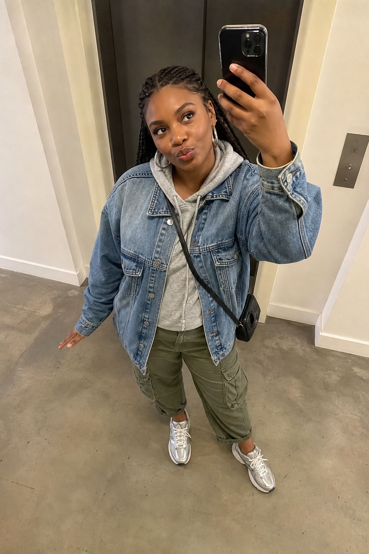 Woman wearing a denim jacket over a hoodie and cargo pants