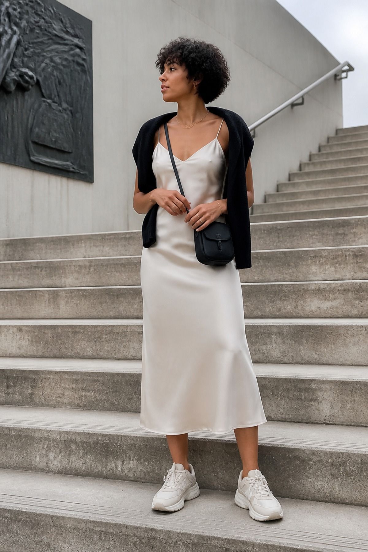 Woman wearing a slip-style midi dress with chunky trainers