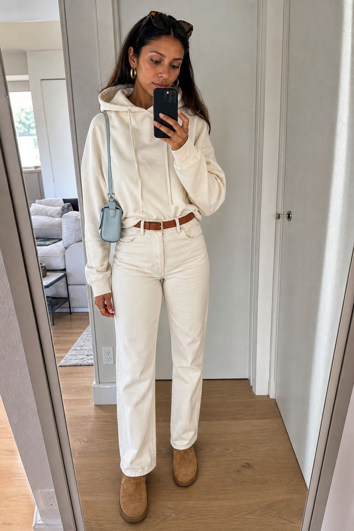 Woman wearing a cream hoodie with ecru jeans
