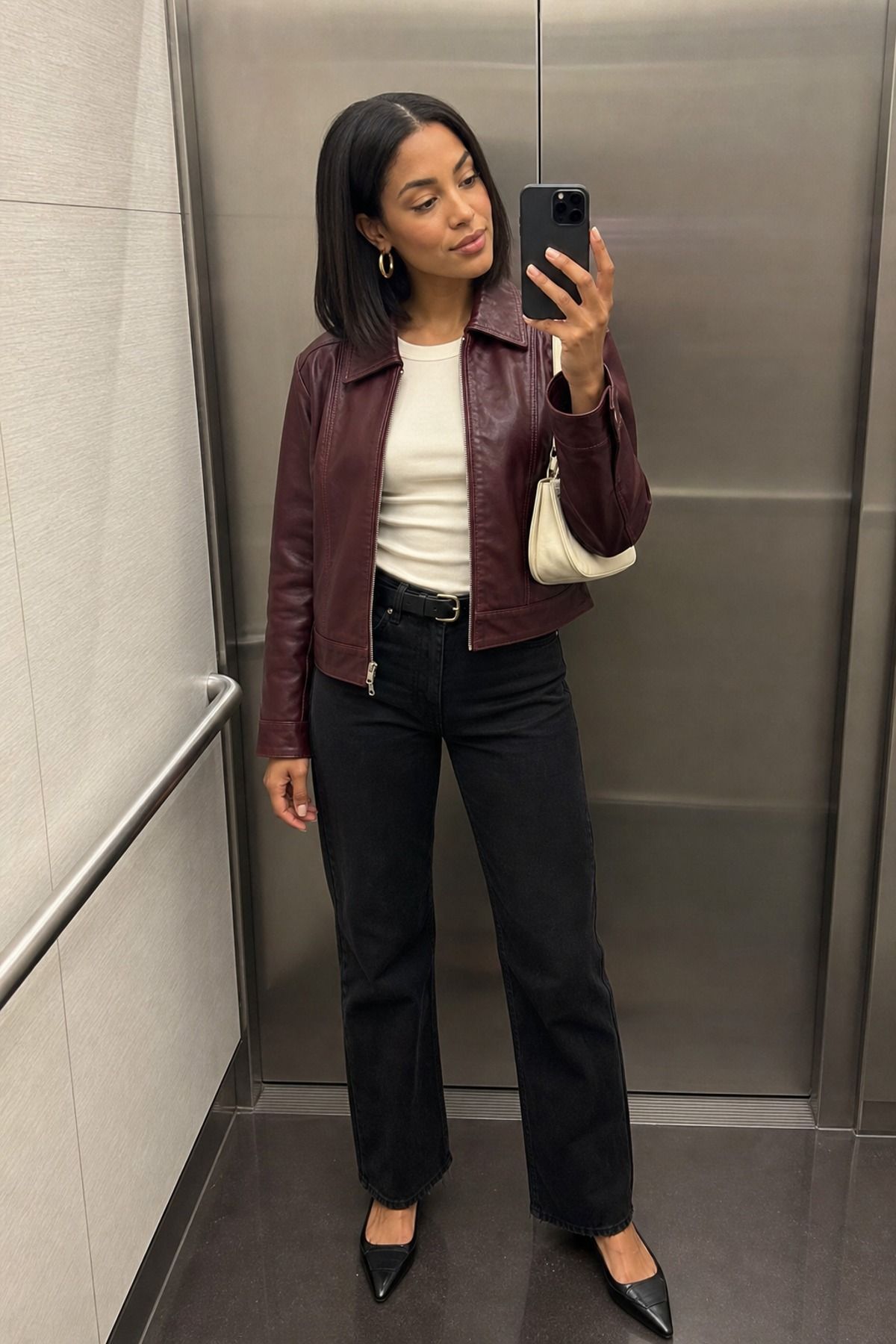 Woman wearing a burgundy leather jacket with black denim