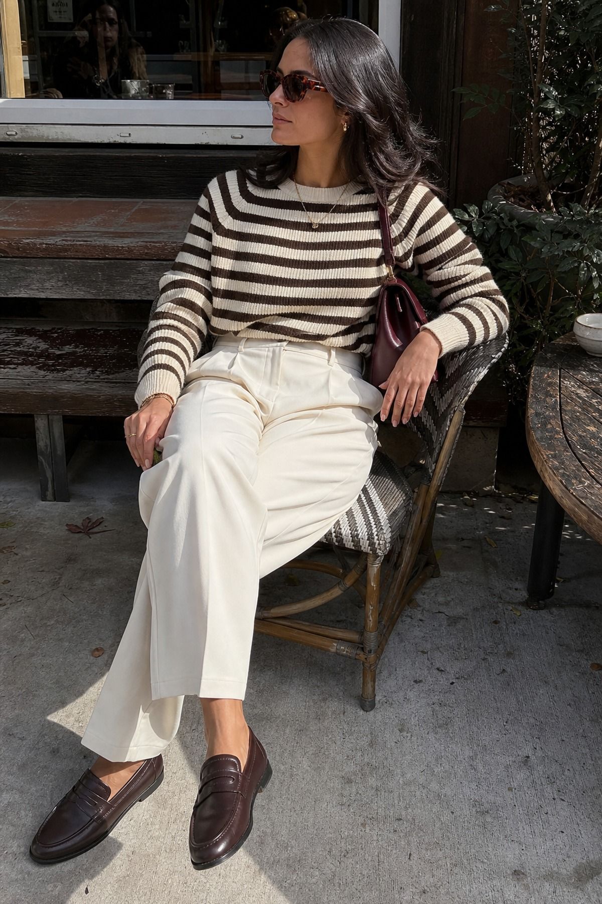 Woman wearing a striped knit sweater with cream trousers