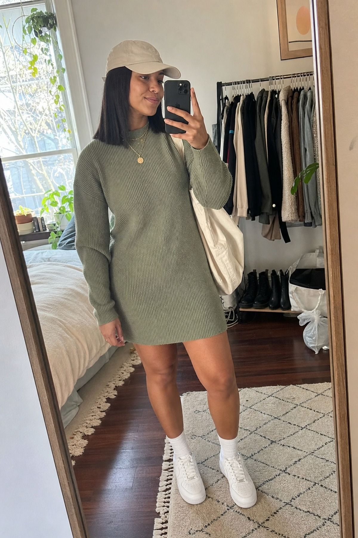 Woman wearing a sweater dress with white sneakers