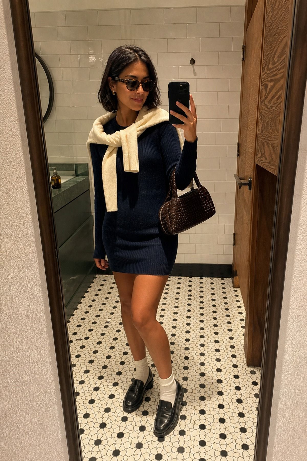 Woman wearing a sweater dress with loafers and socks