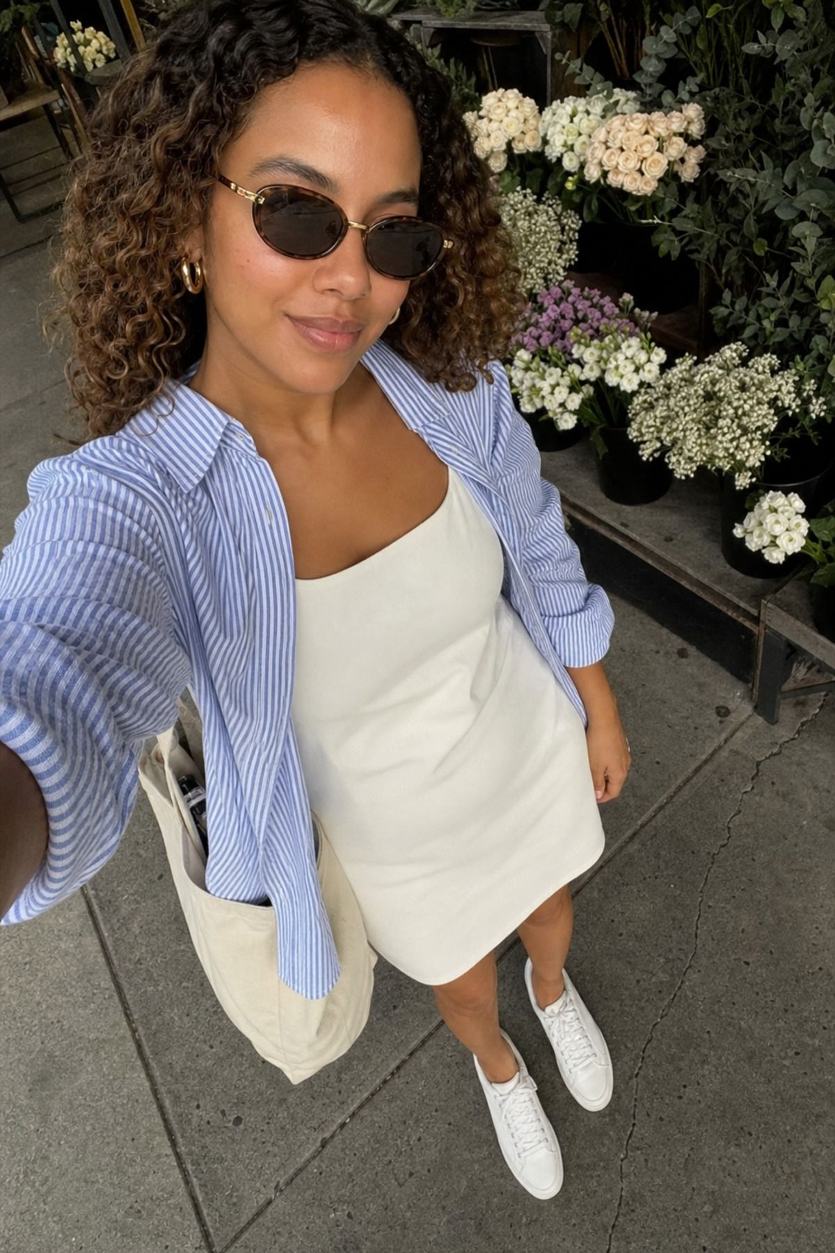 Woman wearing a white dress with a striped shirt layer