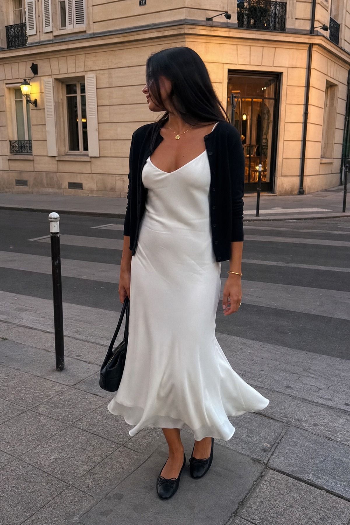 Woman wearing a white dress with a black cardigan